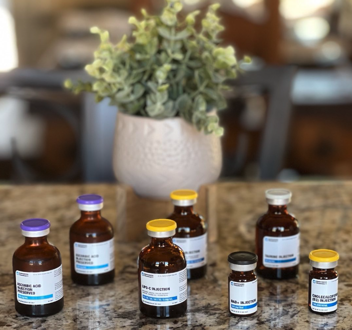 Multiple medicine bottles on a kitchen counter with a plant in a white pot in the background.