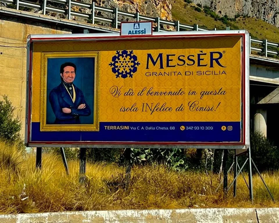 “Benvenuti in questa isola INfelice di Cinisi”: il cartellone pubblicitario di Messèr accende le polemiche