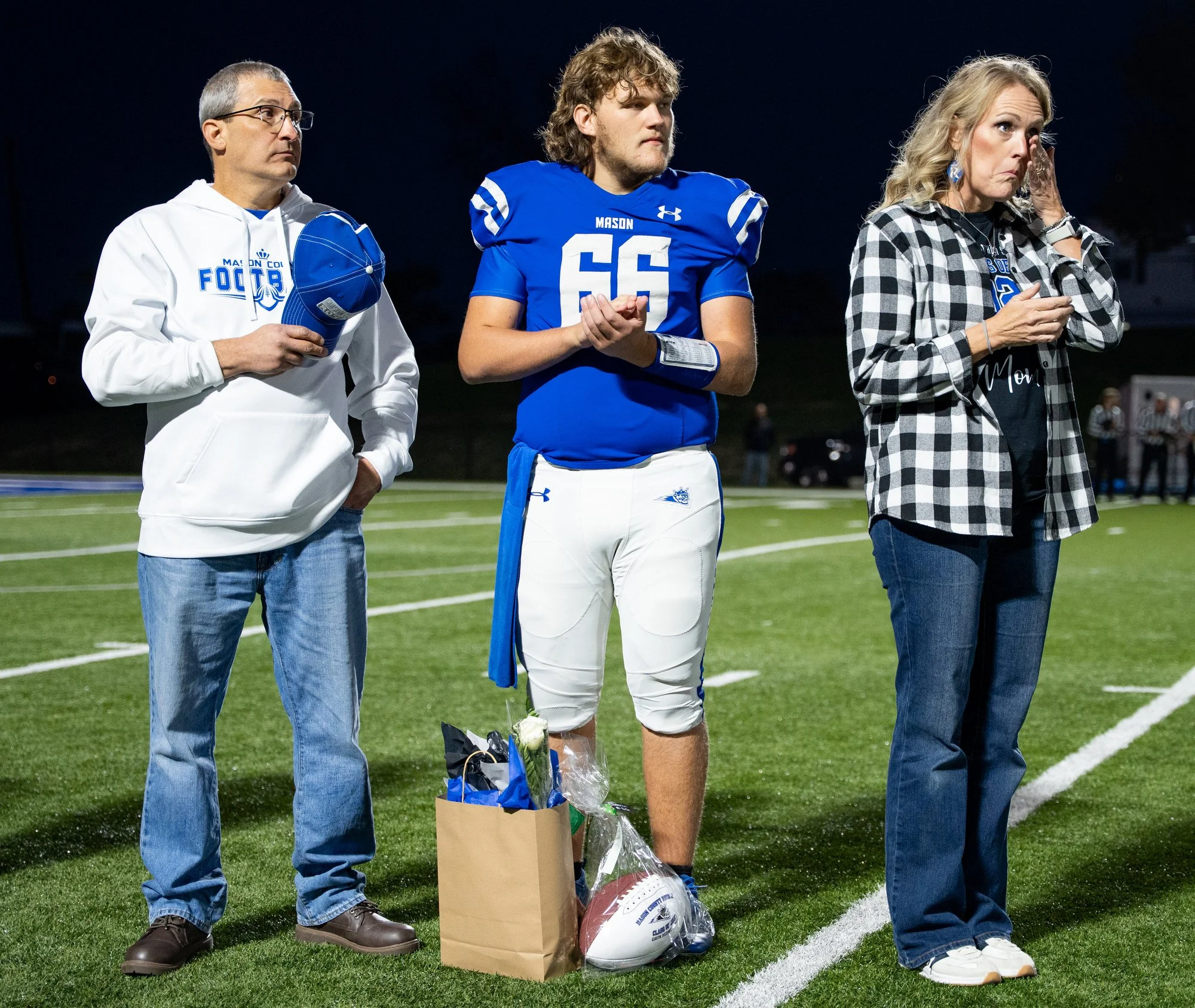 Gavin stands with his parents during the national anthem before his senior night game at Mason County High School in Maysville, Ky., Oct. 24, 2025.
