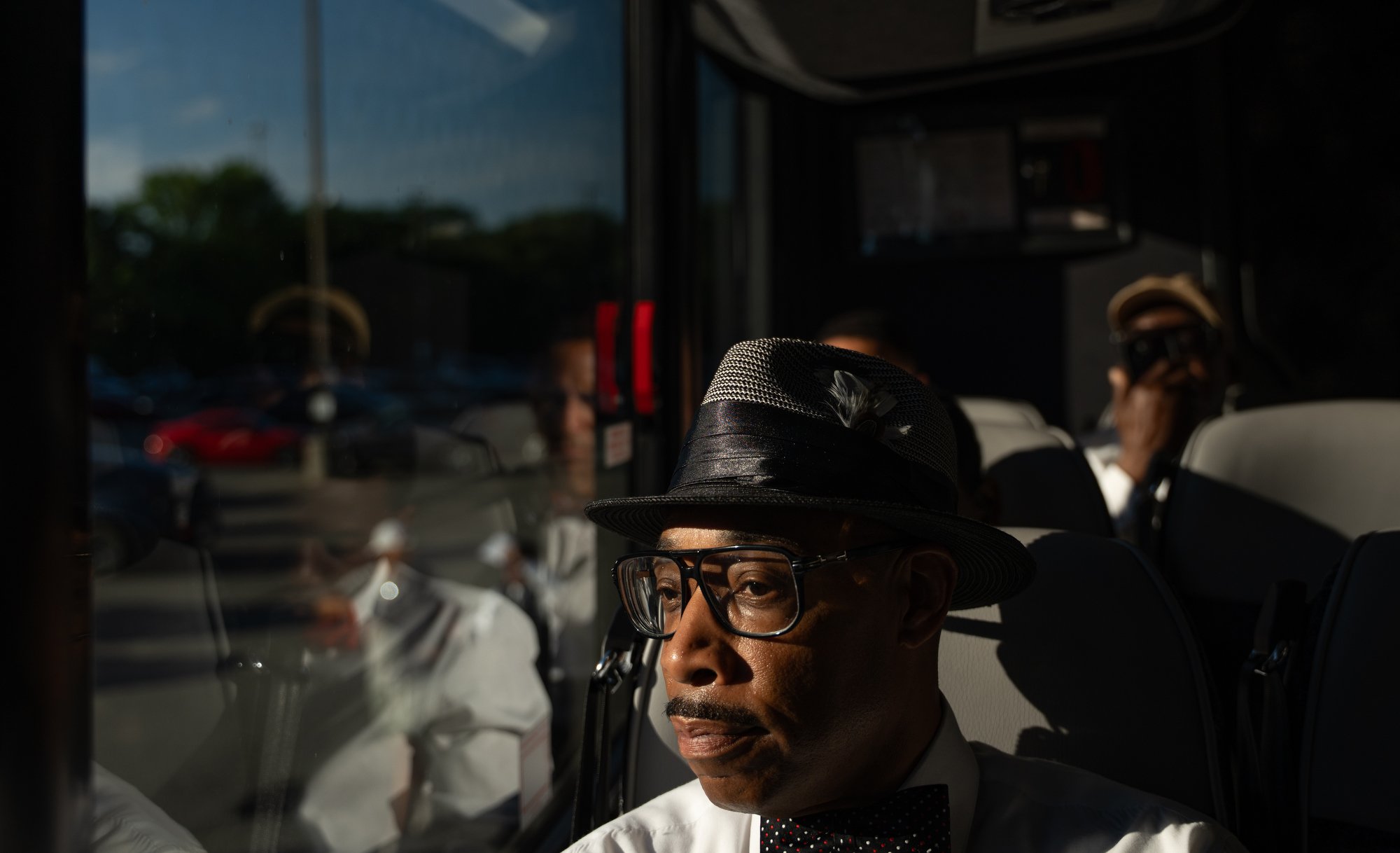 A member of the security detail for the Torch Lit Night Walk Along the Trail of Enslaved Africans, hosted by the Elegba Folklore Society for Juneteenth, looks out the window of the shuttle bus traveling to Manchester Dock on Saturday, June 13, 2026, 