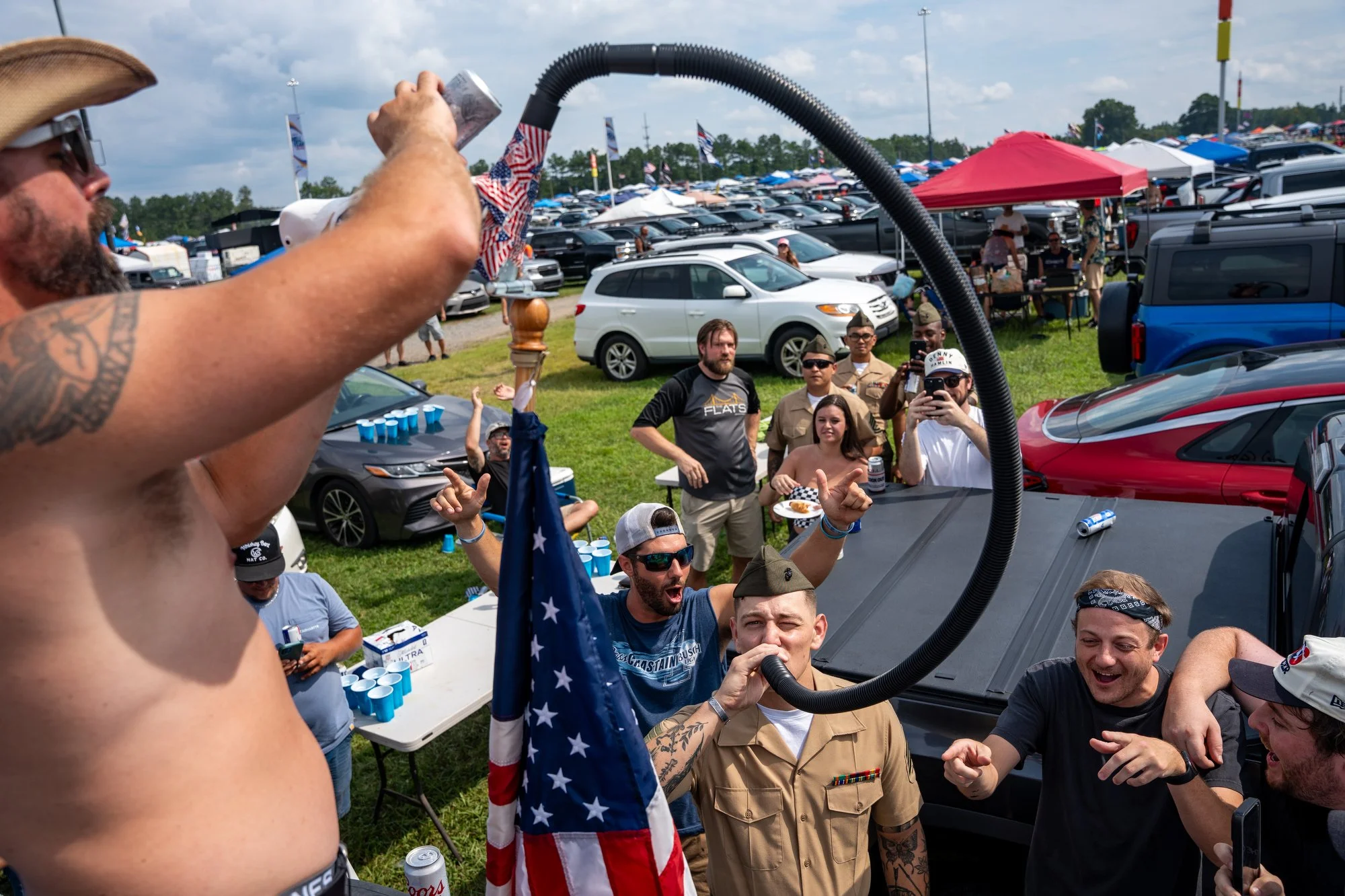 Aaron Sekerdy pours a beer down a beer bong named “Old Glory,” for Sgt John Campbell before the NASCAR Cup Series Cook Out 400 in their kiddie pool at Richmond Raceway, Saturday, Aug. 15, 2026, in Richmond, Va. 