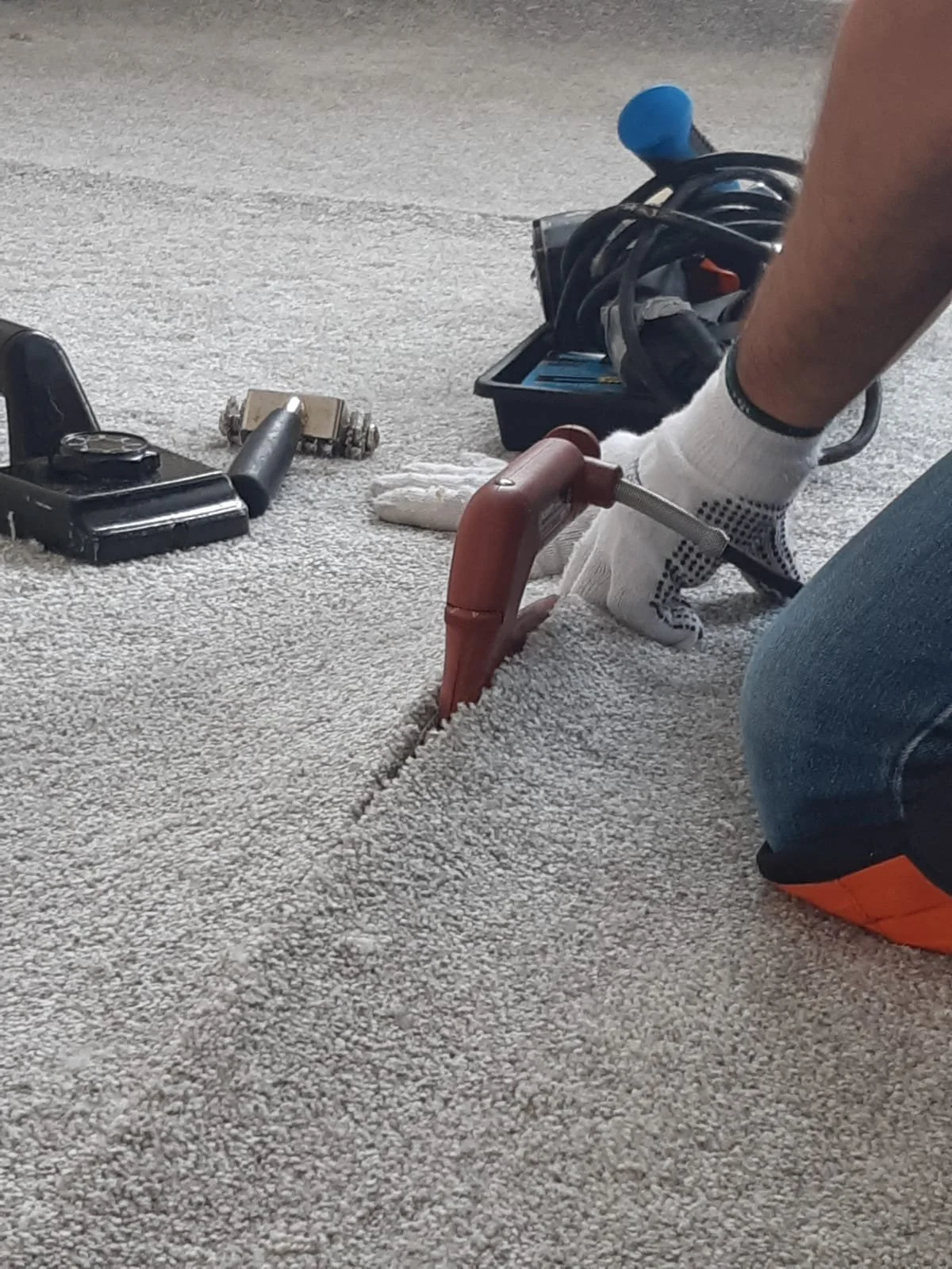 Carpet installer repairing a carpet seam with a carpet iron