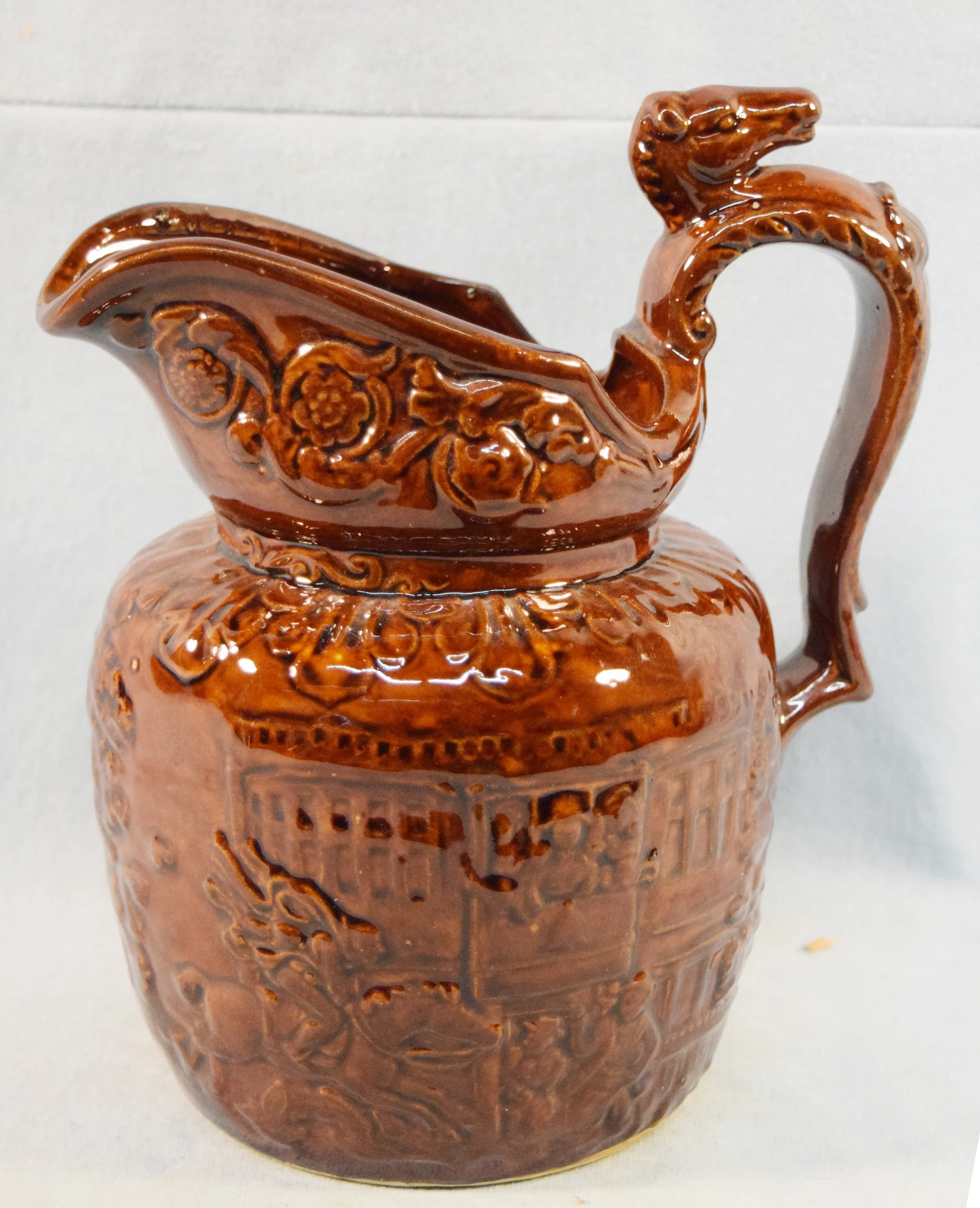 Rockingham Pottery brown glazed pitcher, horse race handle, 8" tall, circa 1920s, excellent condition