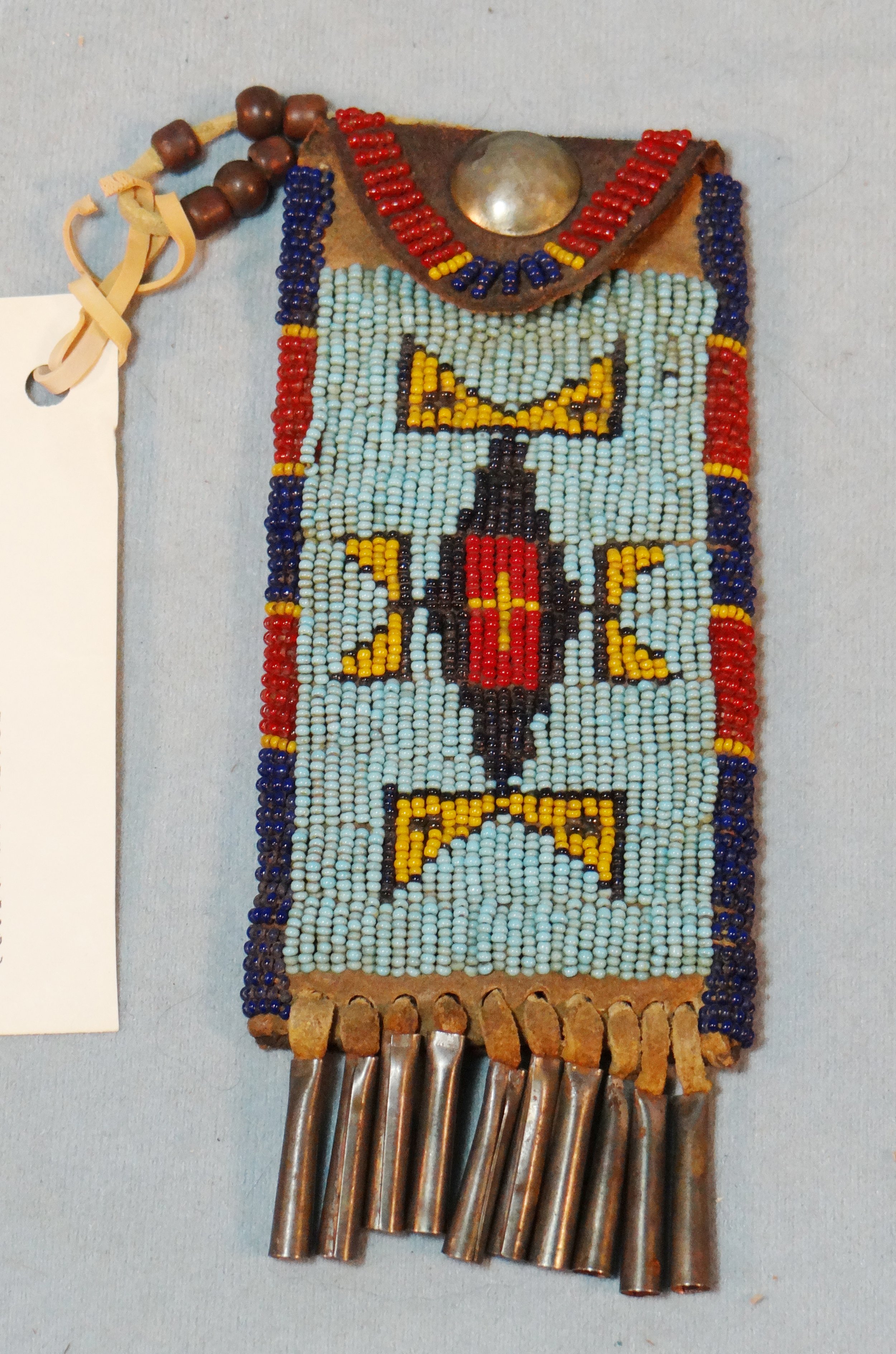 Beaded whetstone/knife case, lazy stitch, 10 tin cones, brass button, sinew sewn, ca. 1880's and small 6" catlinite pipe bowl
