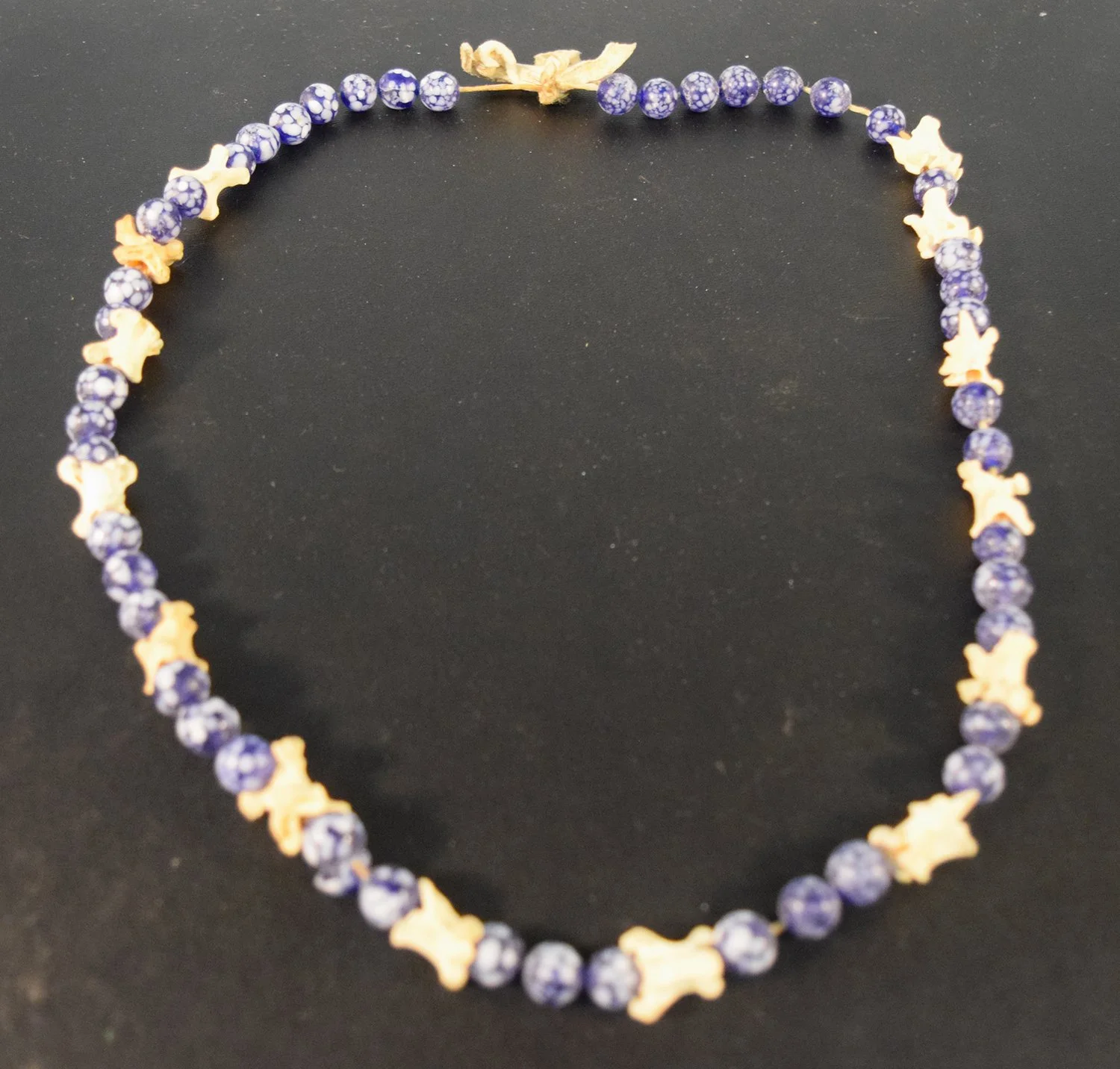Blue dappled trade bead necklace with small animal vertebrae, 13"

