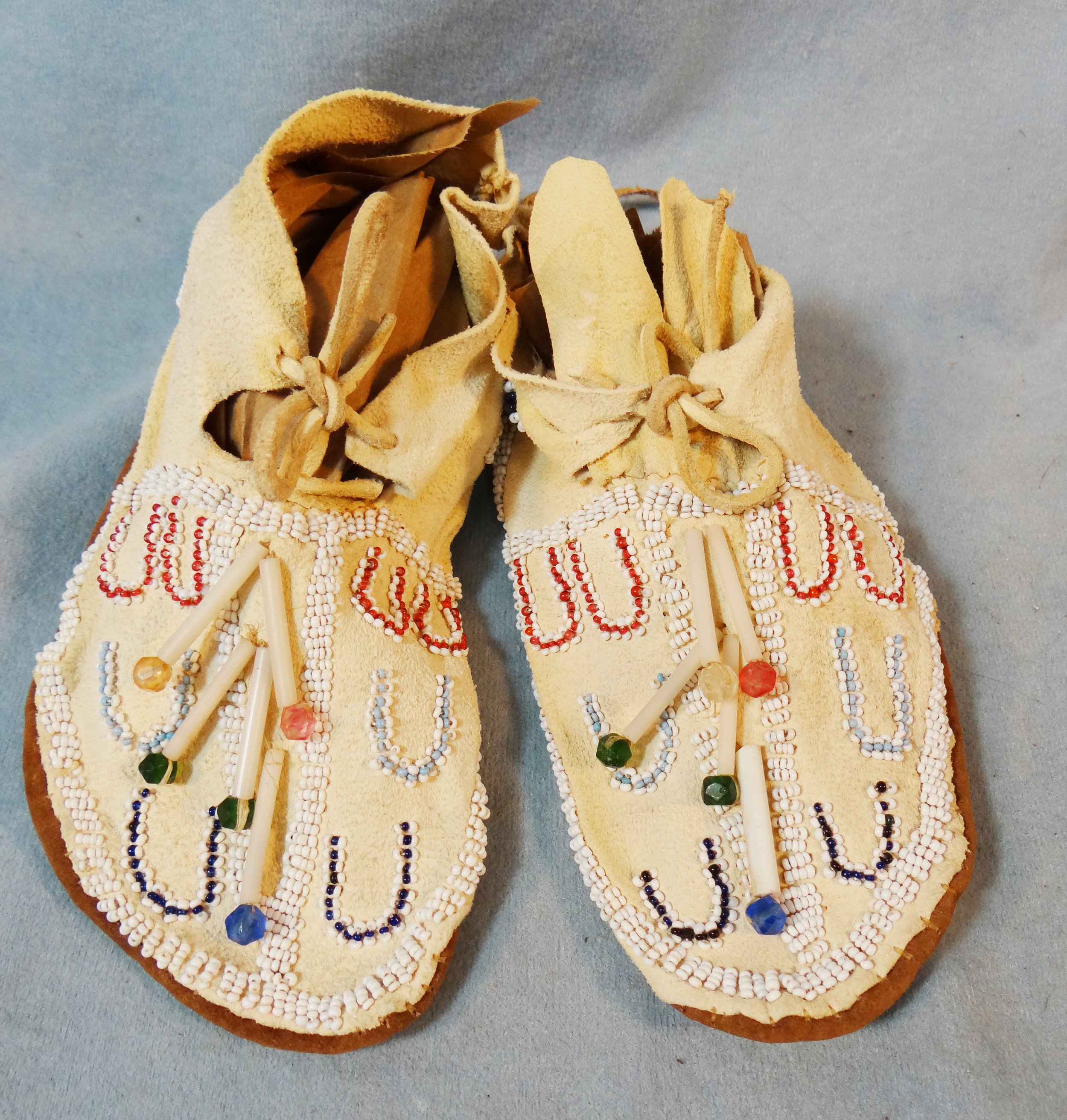 Child's beaded moccasins in display case
