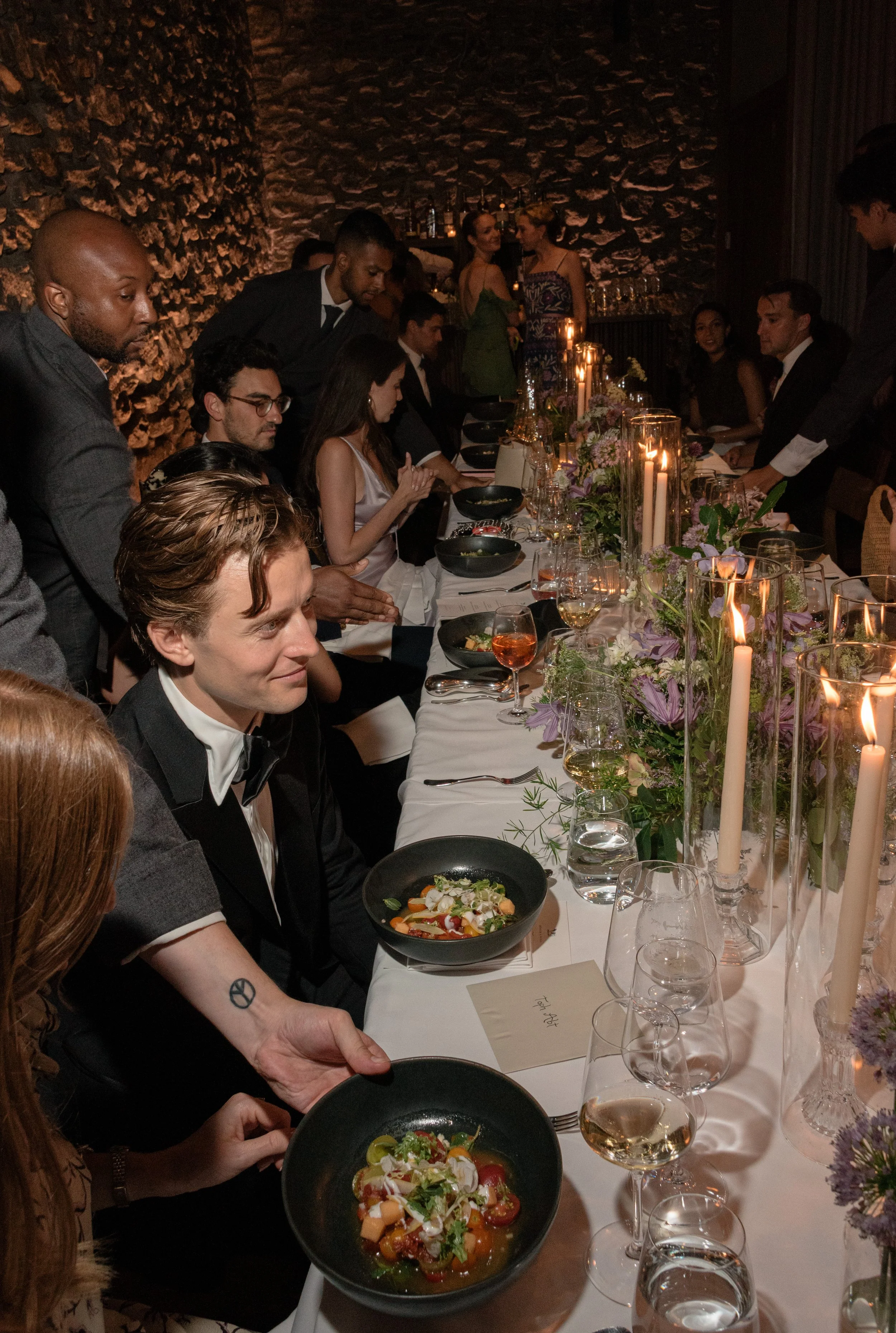 Guests seated around the reception table with plated courses and floral centerpieces.