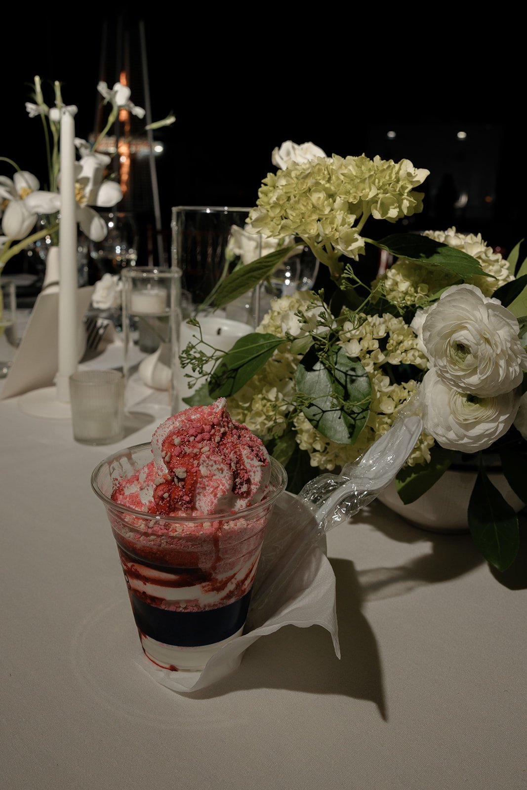 Wedding dessert and floral details arranged beside candlelight during the evening reception at Goodstone Inn.