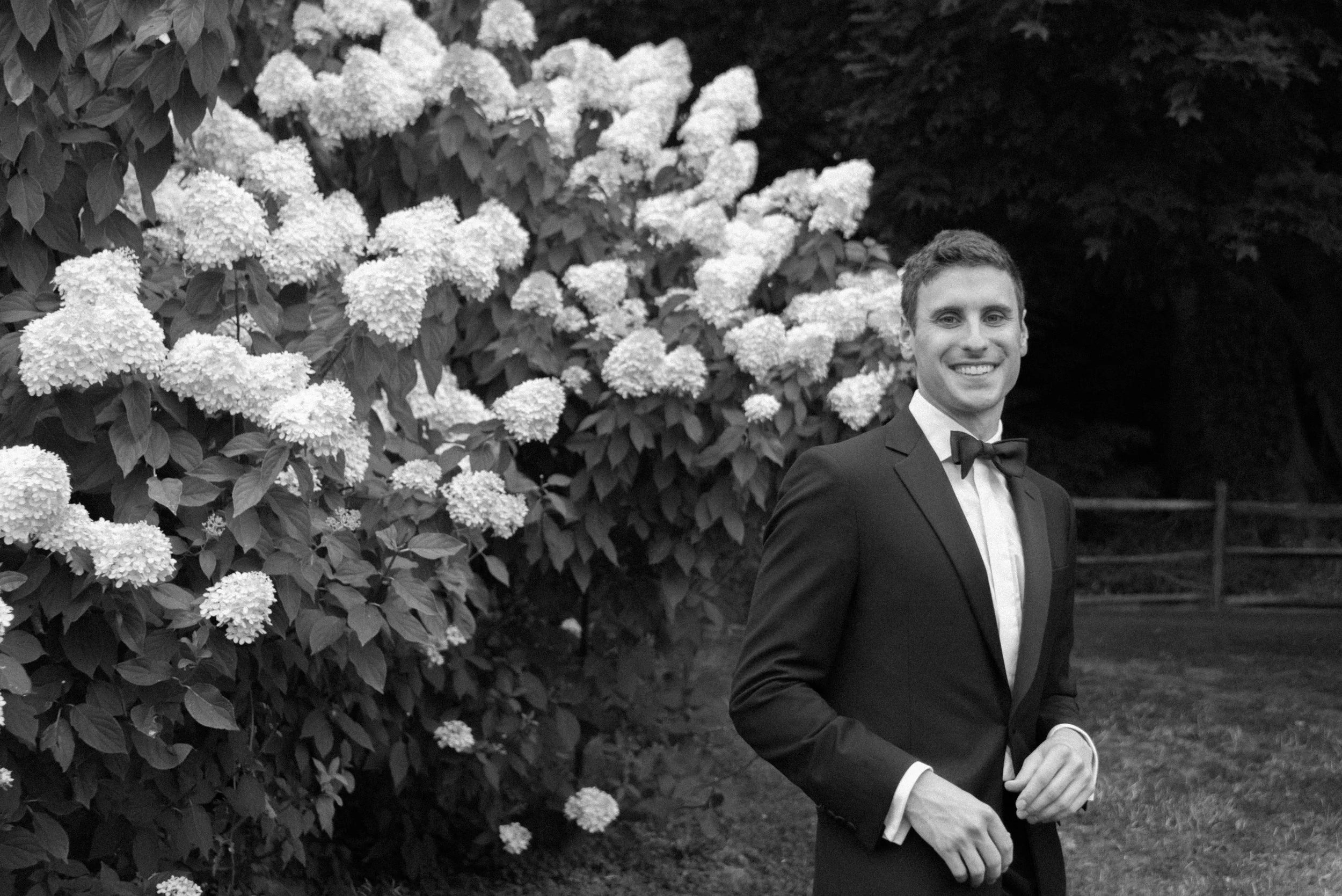 A candid capture of the groom as he turns back in front of the summer hydrangeas. 