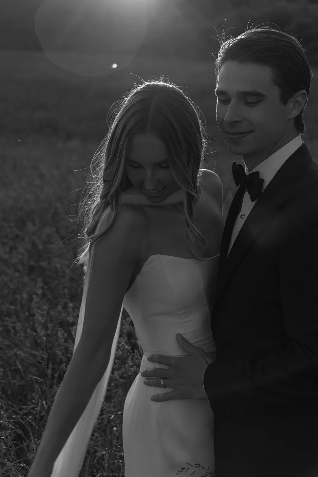 Black-and-white close portrait of the bride and groom holding each other during sunset portraits at Goodstone Inn.