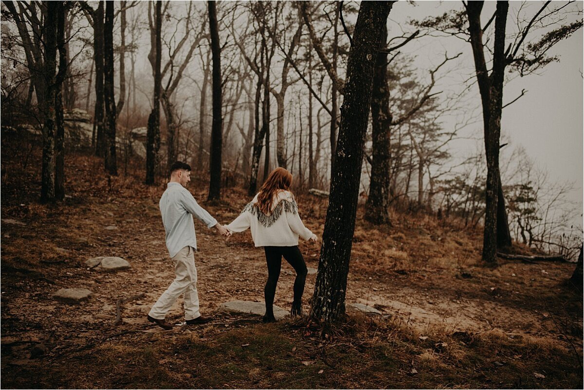  The engaged couple walks toward the foggy cliff on   Lookout Mountain, Tennessee 