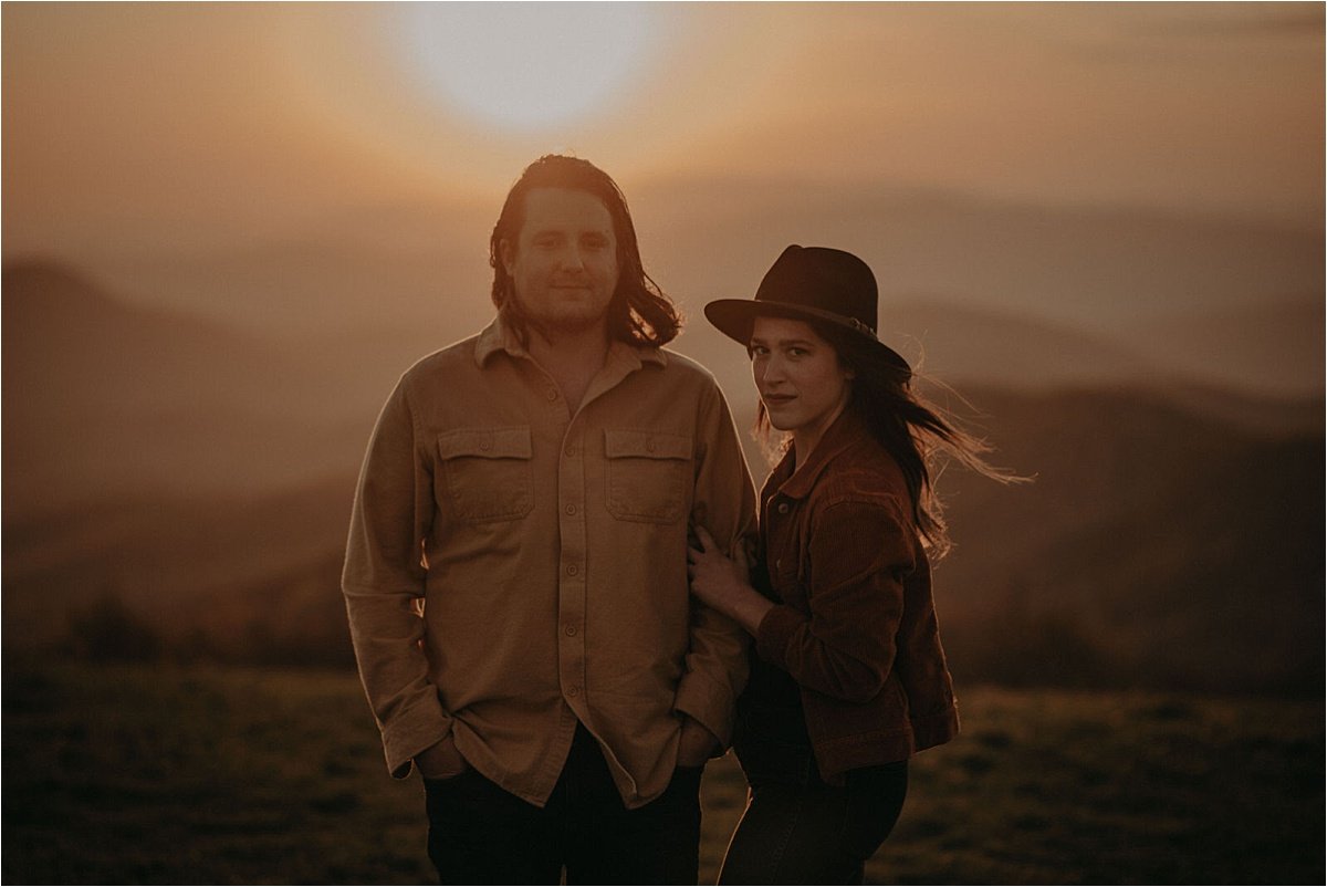 The bride wore a rust jacket and boho black hat for this mountain engagement session