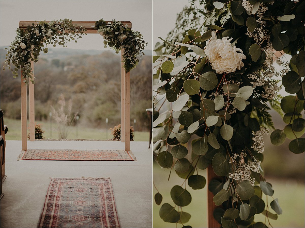  A rug runner leads to the ceremony altar decked with eucalyptus and greenery and white blooms at this Barn in the Bend wedding.  