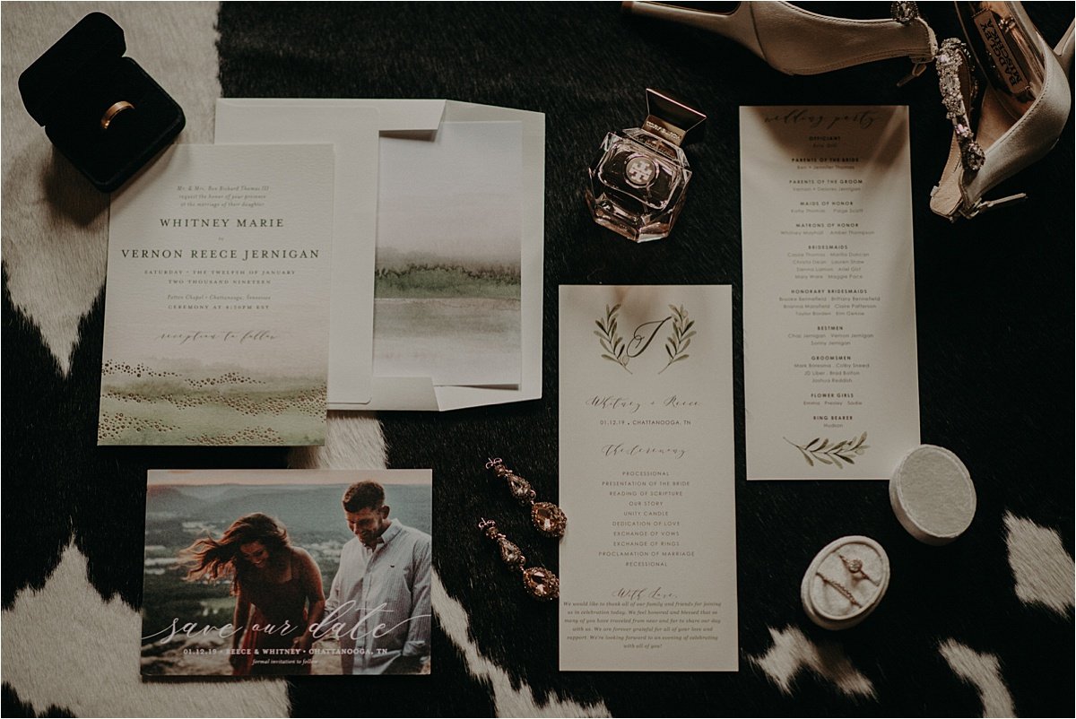 Wedding details and stationary laid out on a cow print rug in a Chattanooga, Tennessee Airbnb