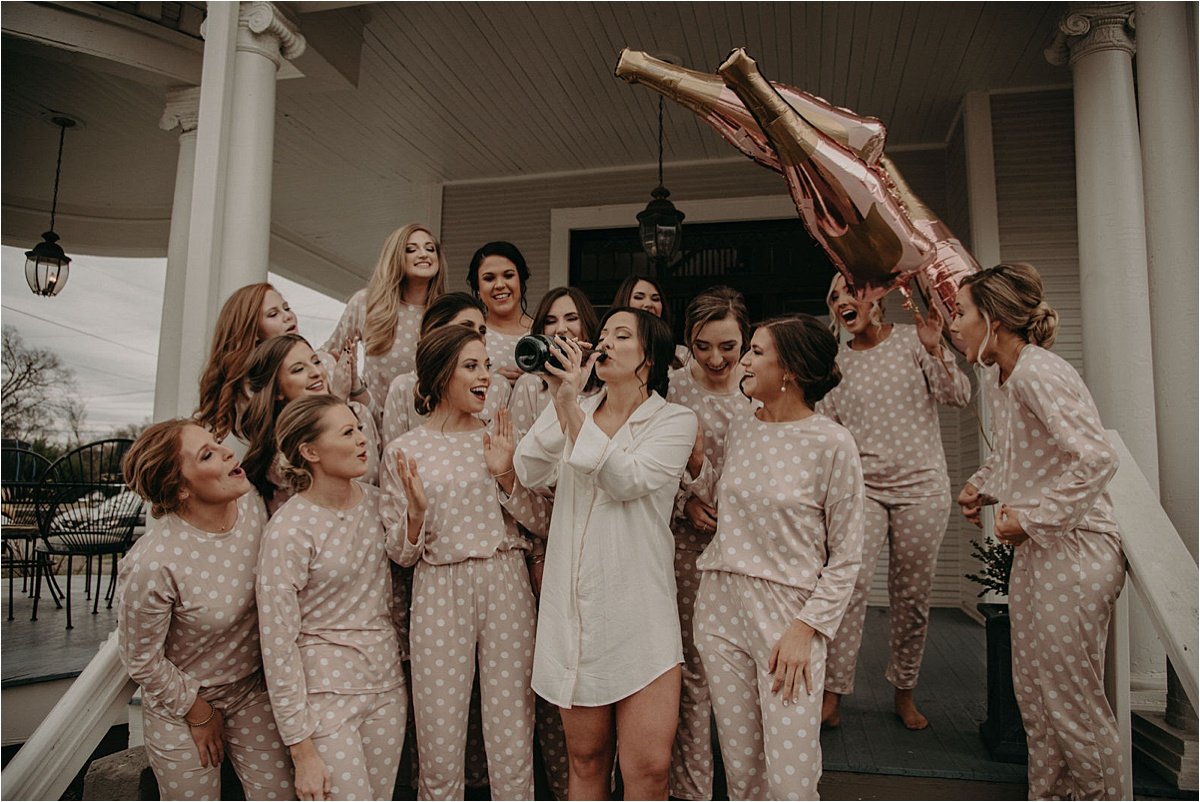 The bride drinking champagne straight from the bottle on the porch of their Chattanooga Airbnb