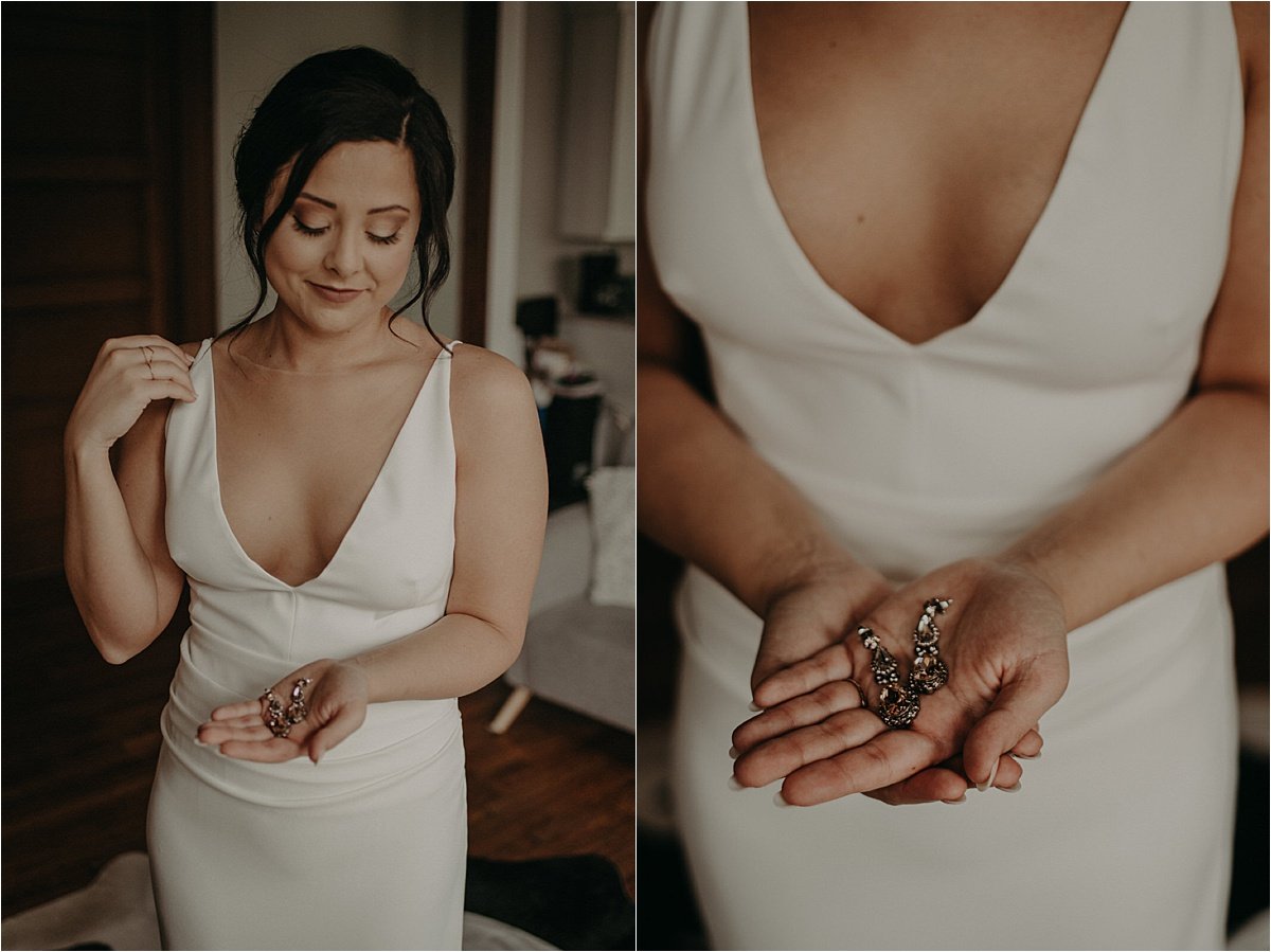 The bride holds her earrings in her hands