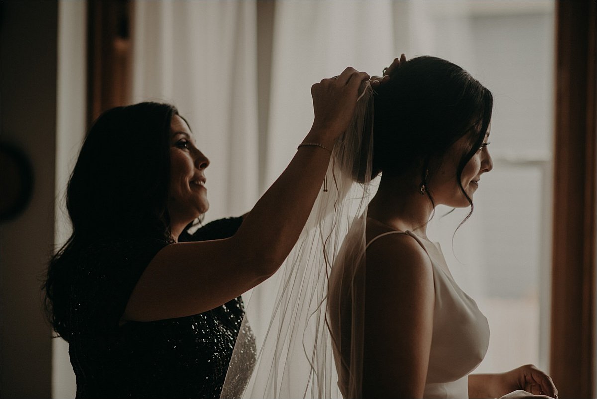 The mother of the bride positions her daughter's wedding veil