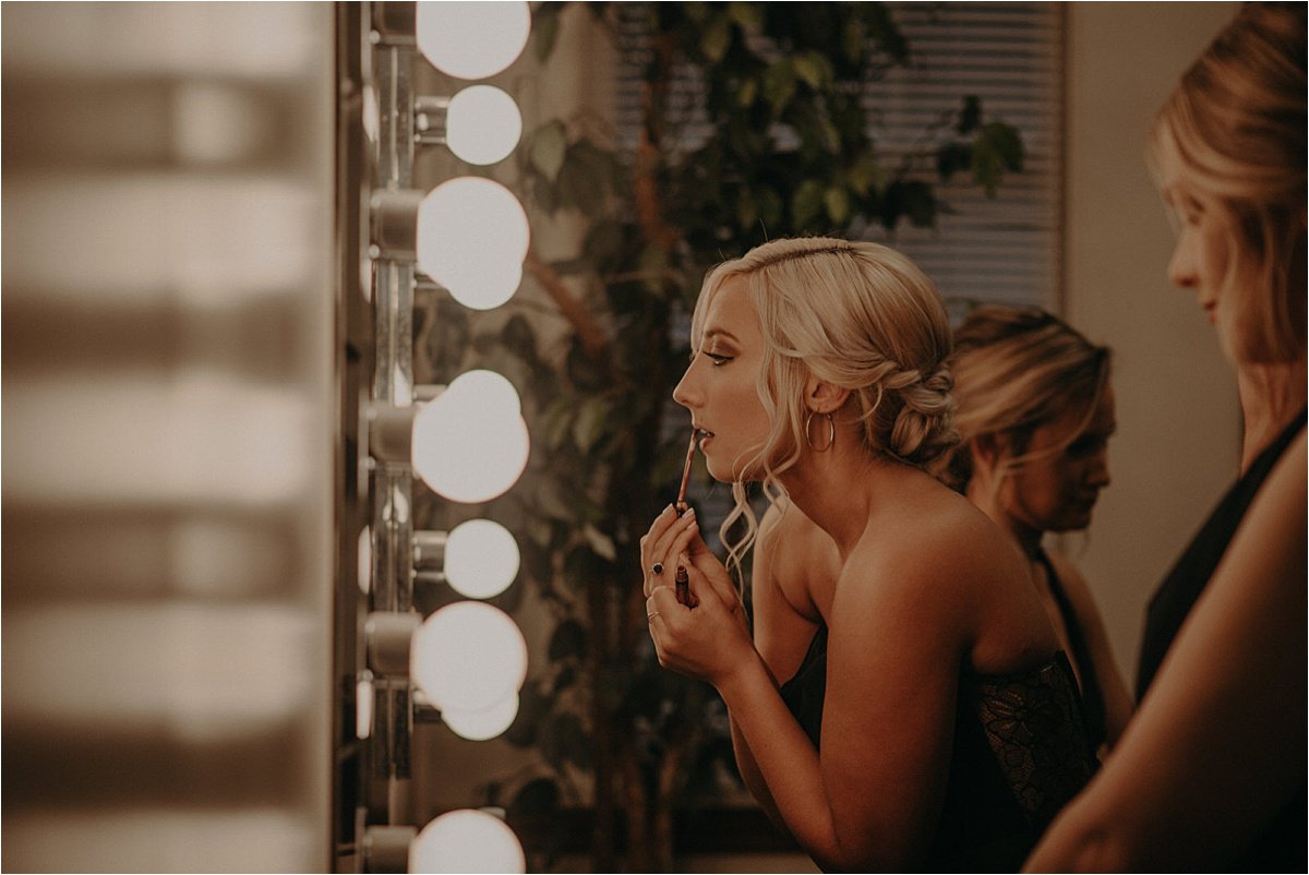 The bridesmaids touch up their makeup before the wedding ceremony