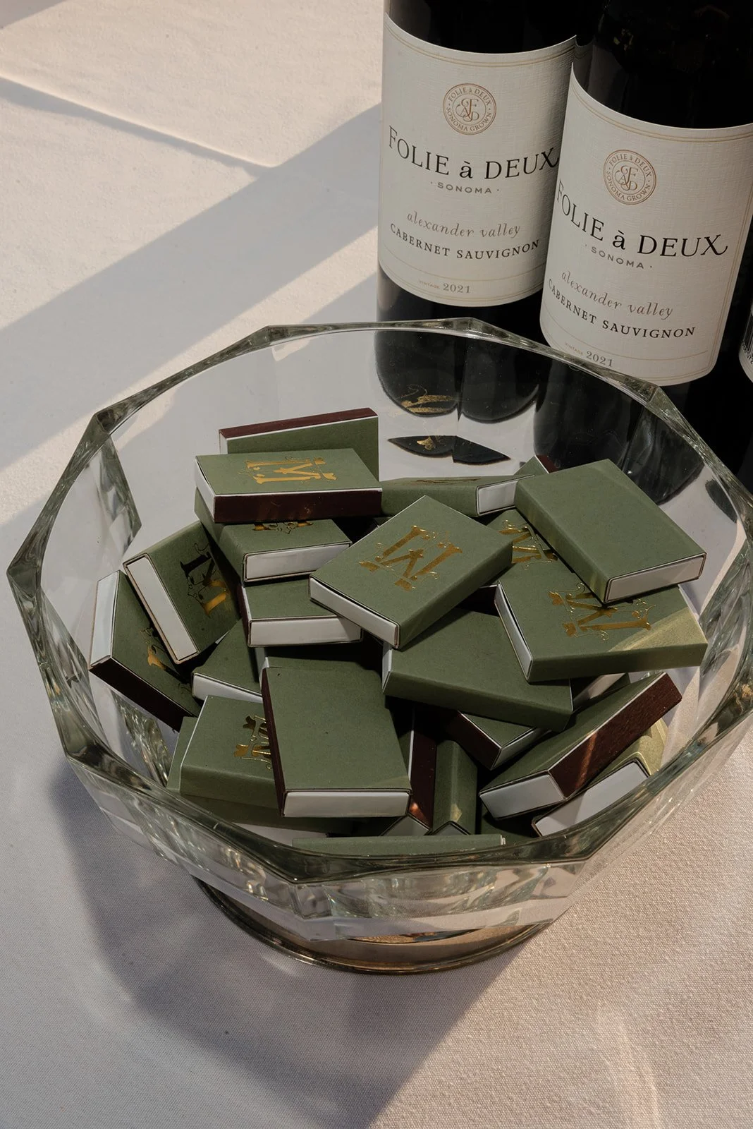 Green wedding favor match boxes and wine bottles arranged together at a Goodstone Inn reception.
