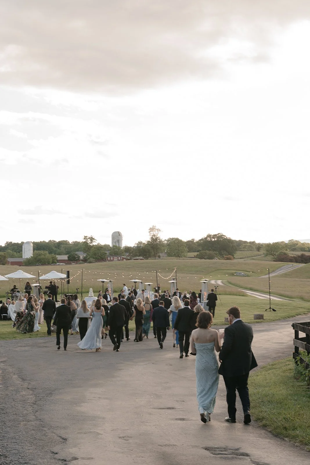Wedding guests walking through the outdoor reception area in the Hayfield at Goodstone Inn.