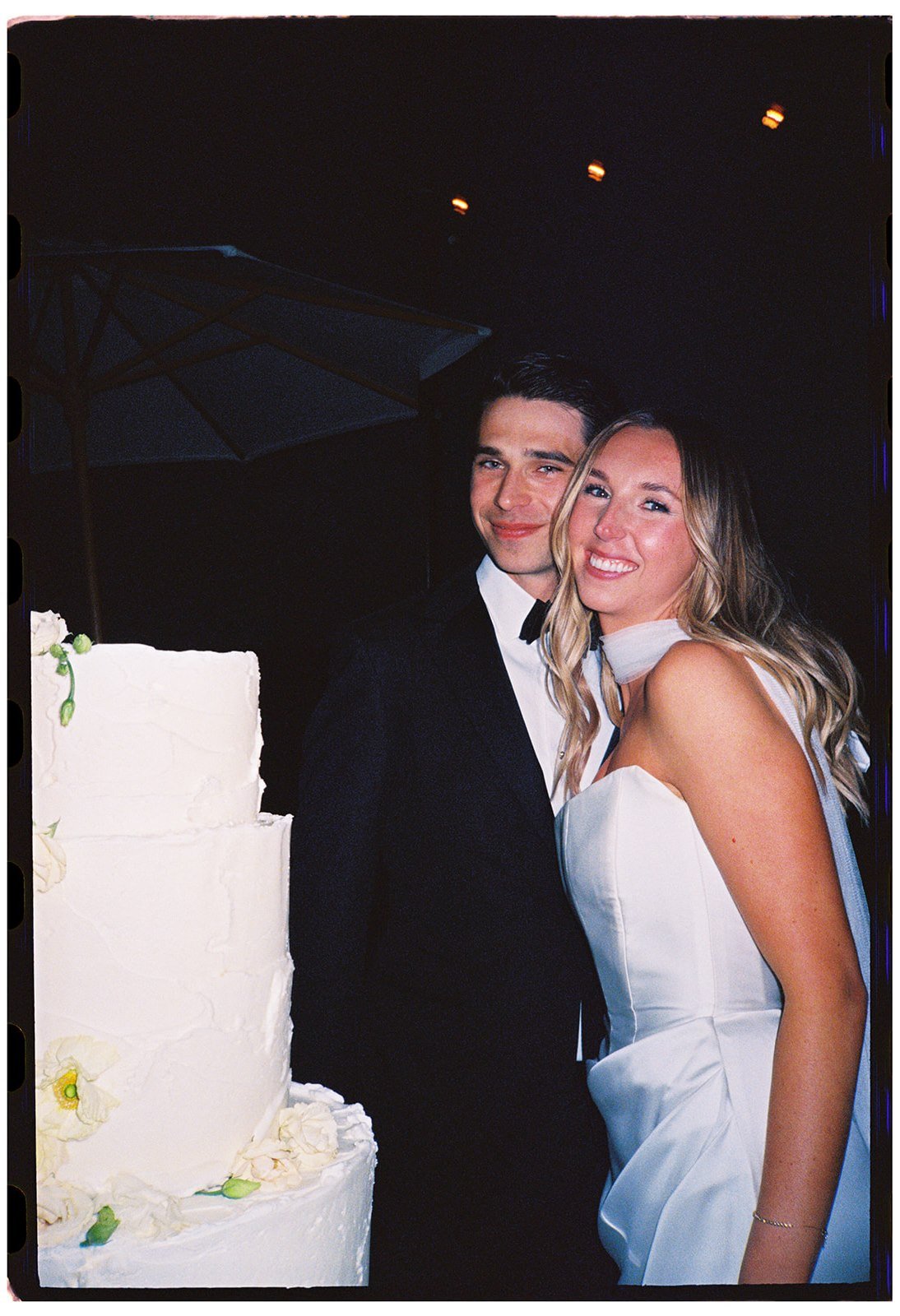 Bride and groom laughing together beside their wedding cake during the reception at Goodstone Inn captured on 35mm film. 
