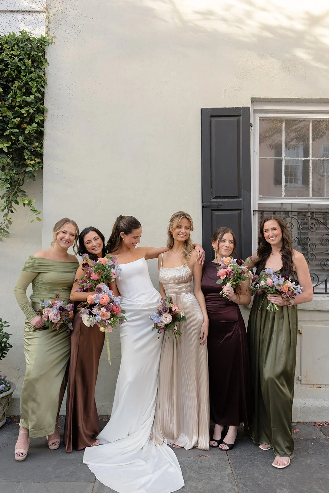 Bride and bridesmaids holding bouquets during a multi-day wedding celebration in Charleston, photographed with a natural editorial approach.