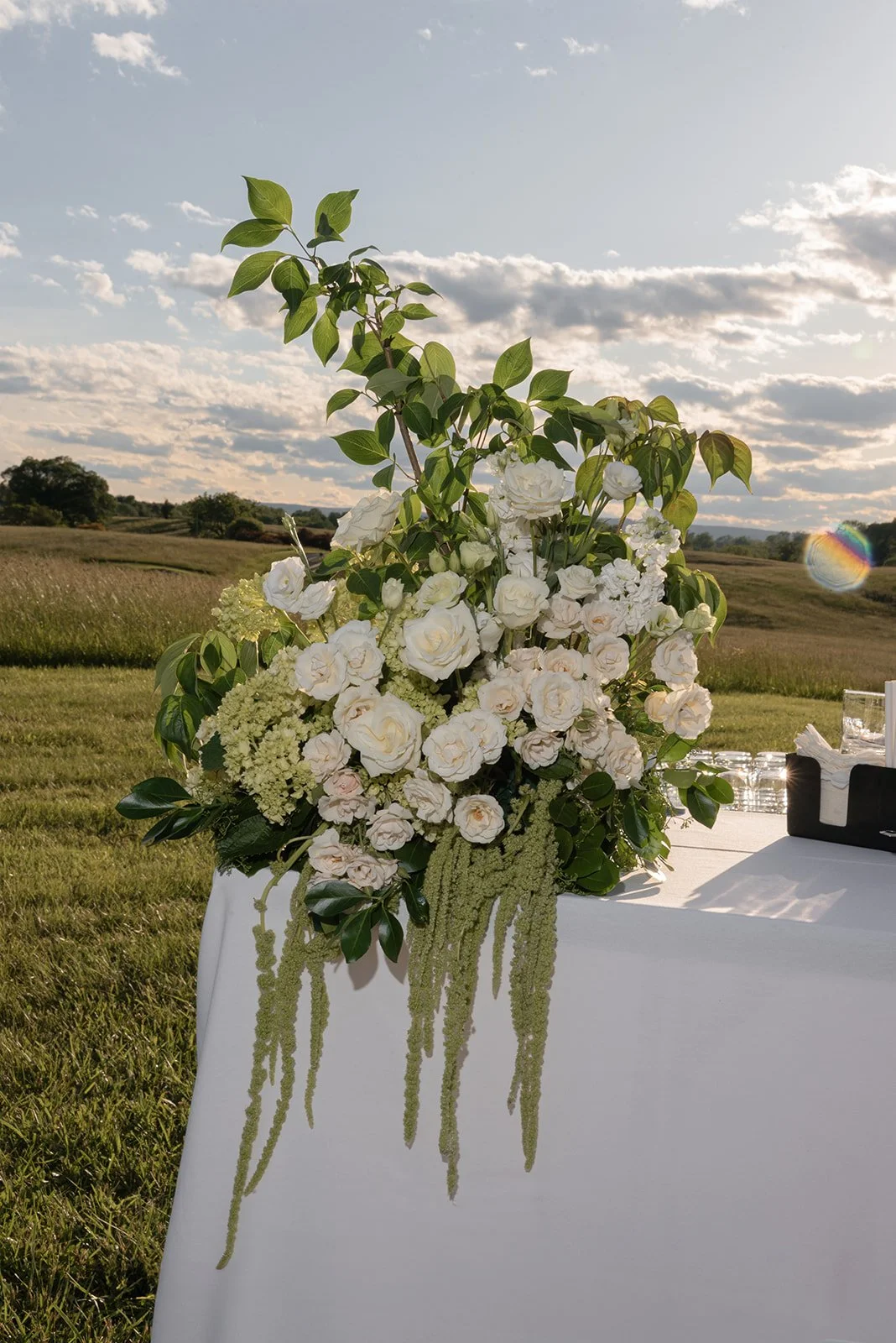Tall white and green floral arrangement displayed outdoors against the Virginia countryside at Goodstone Inn.