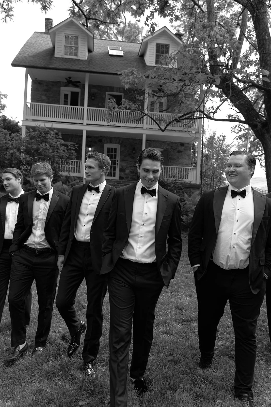 Black-and-white portrait of the groom and groomsmen outside historic buildings at Goodstone Inn.