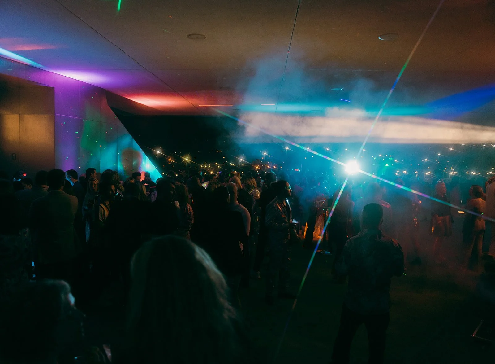 Underground pop-up dance floor orchestrated by an art museum and illuminated by colorful lights and movement, capturing the energy and atmosphere of an unforgettable celebration.