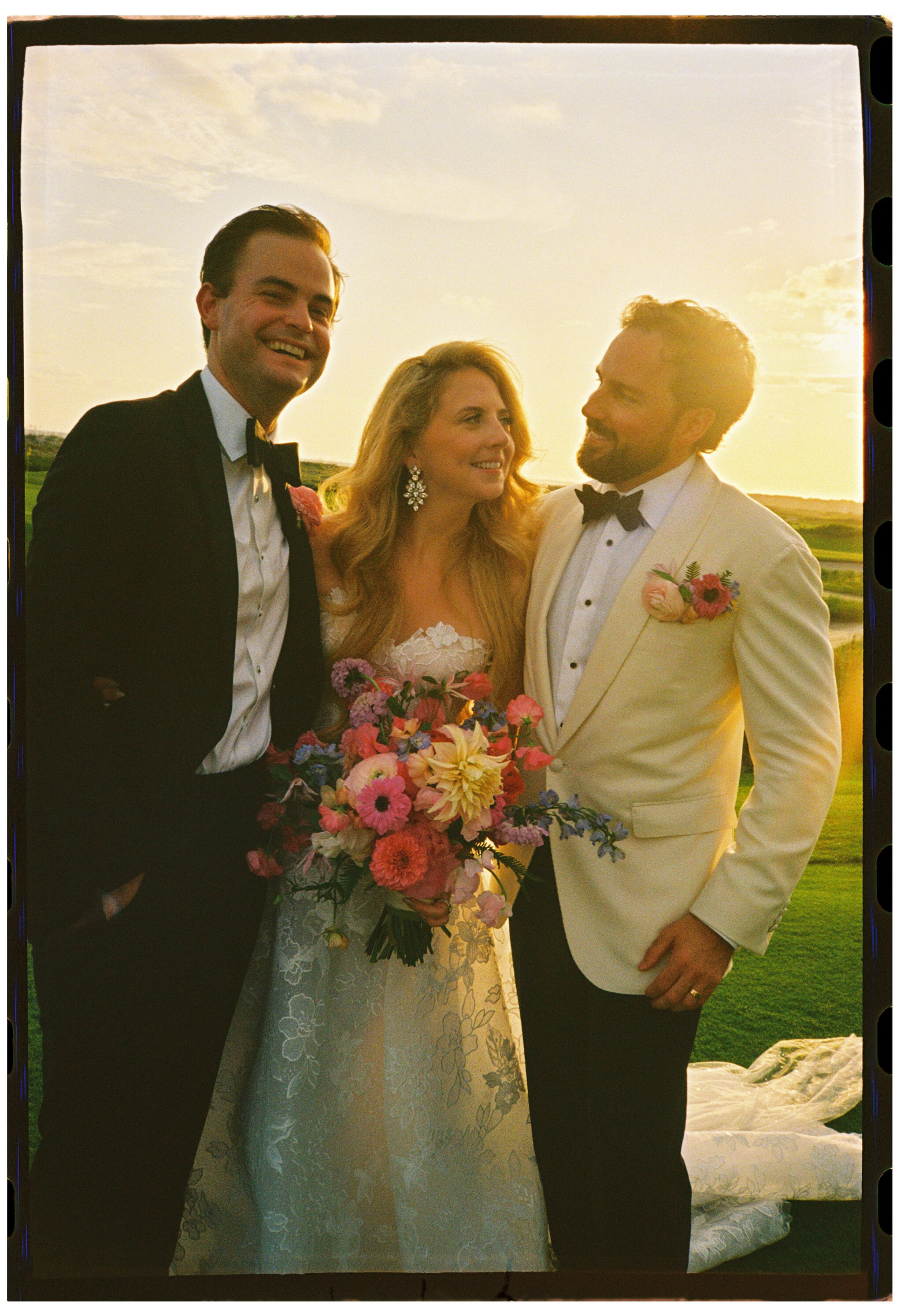 Film portrait of Katie and Trevor with a guest in golden evening light at The Ocean Course.