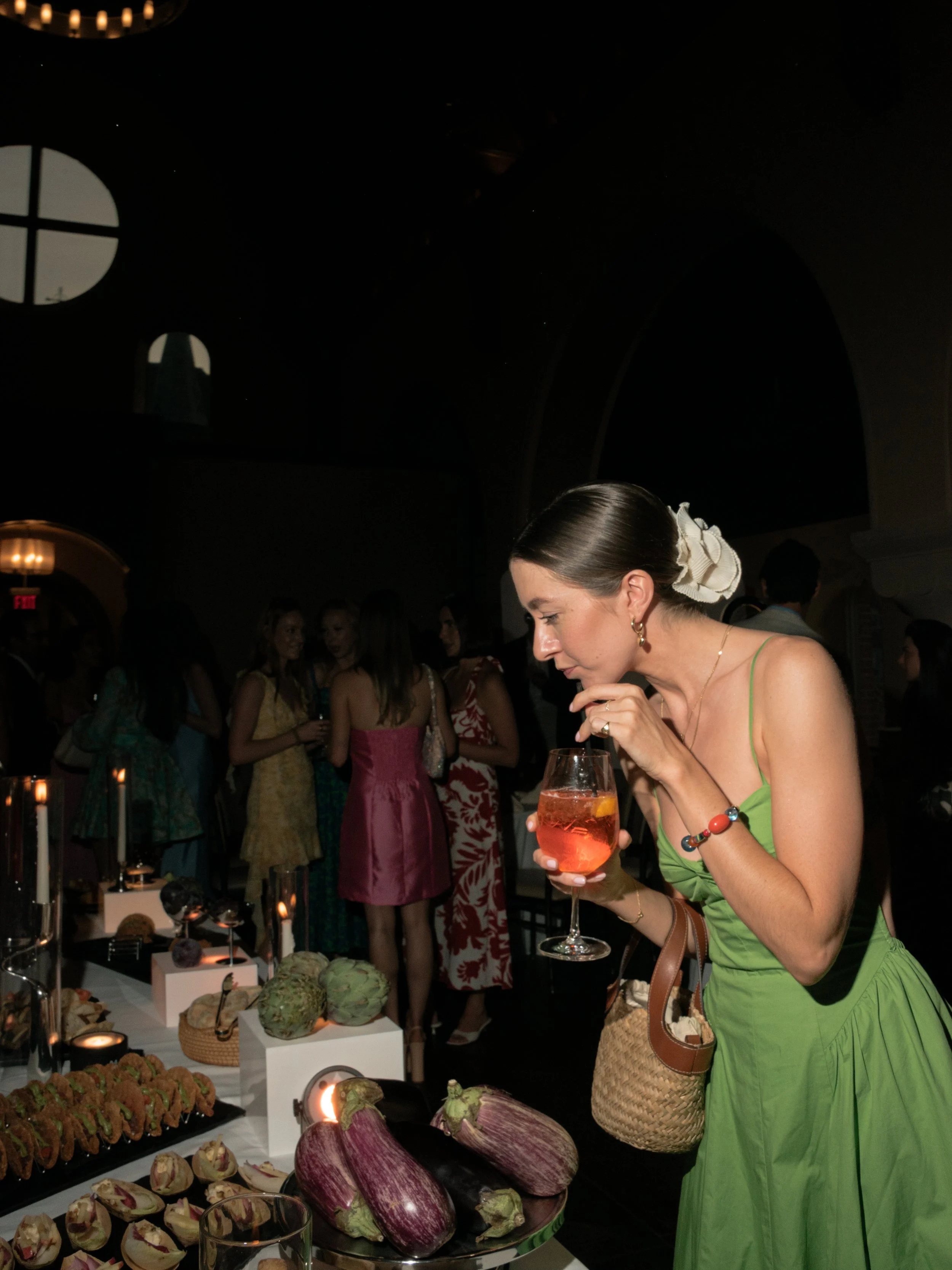 Guest in a green dress enjoying the interactive food and cocktail experience at the rehearsal dinner.