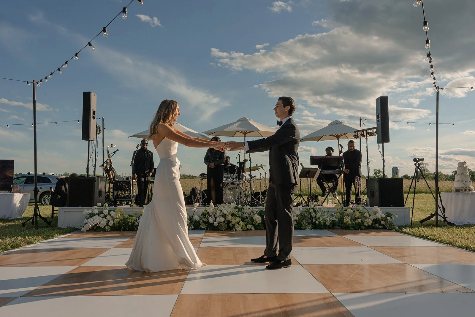 Bride and groom dancing on a checkerboard dance floor with a live band behind them at Goodstone Inn.