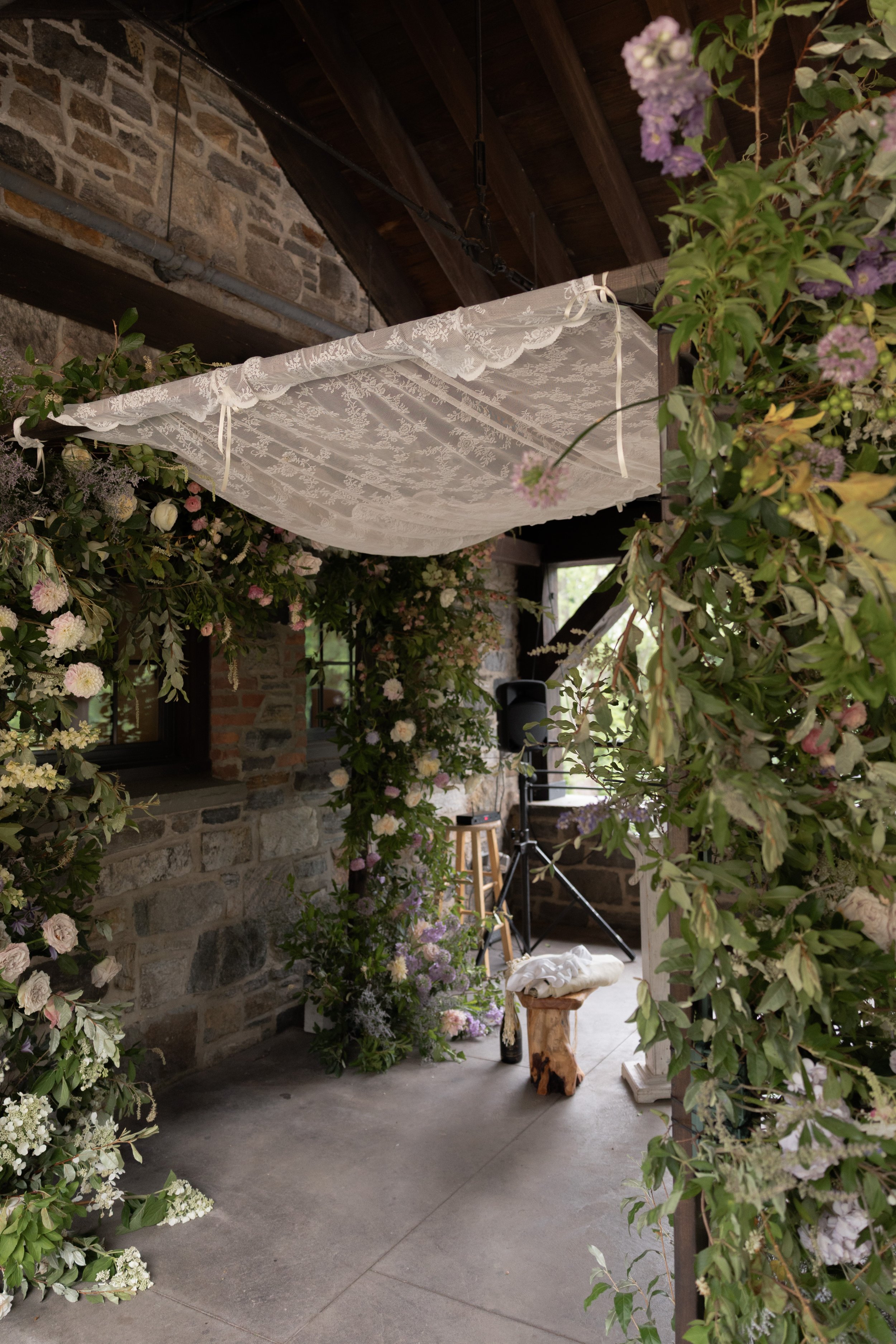 Floral ceremony installation by Wild and Birch beneath the pergola at Blue Hill at Stone Barns during a Hudson Valley wedding.