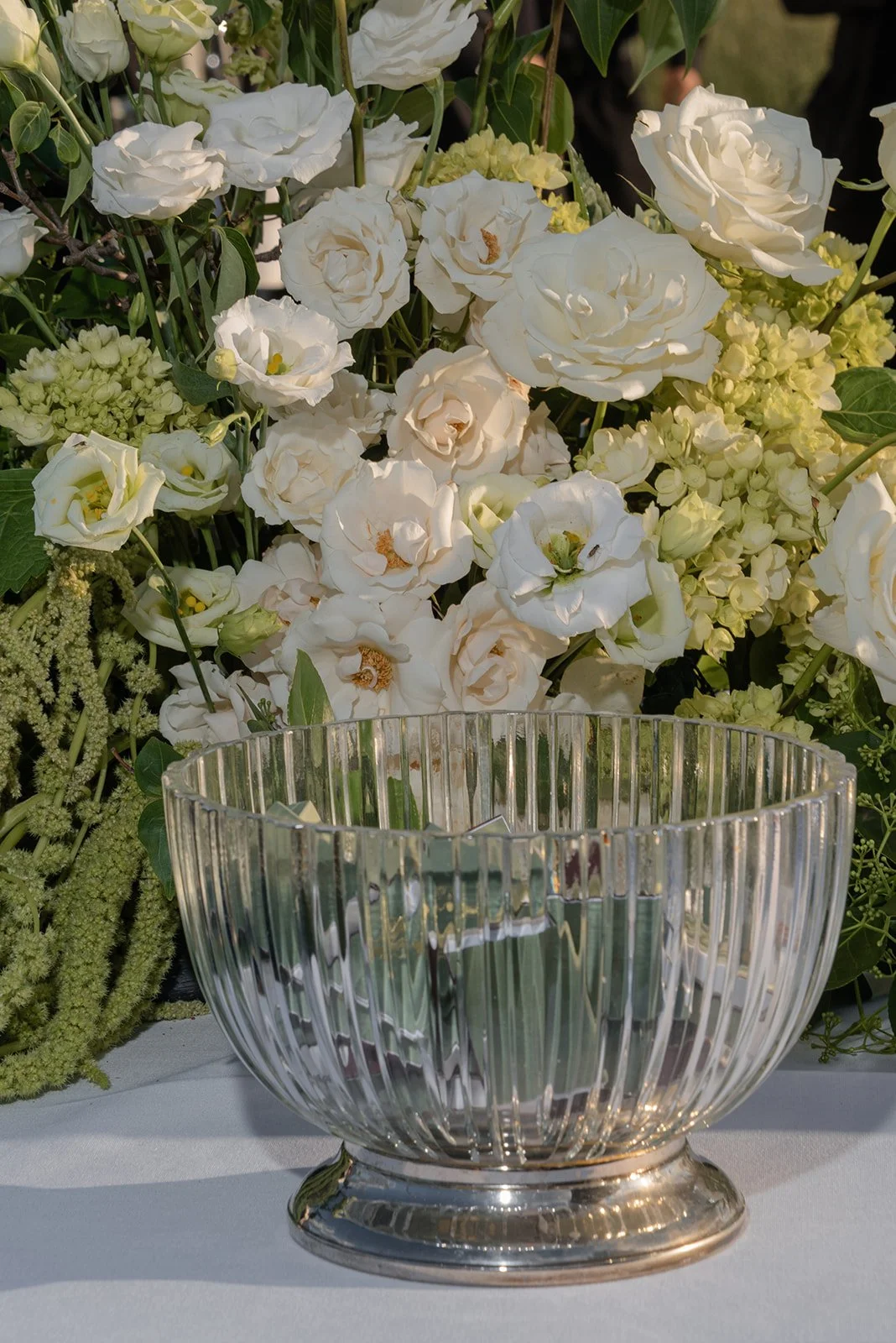 White garden flowers arranged beside clear glassware filled with custom matchbooks on an outdoor reception table at Goodstone Inn.
