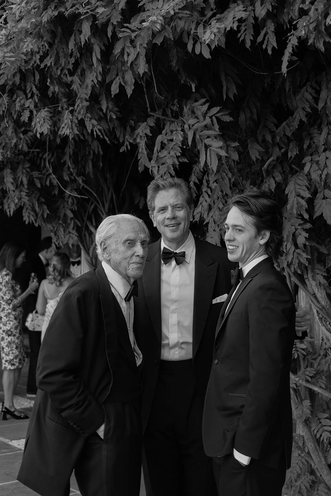 Black-and-white photograph of wedding guests who share three generations gathered together during cocktail hour at Goodstone Inn.
