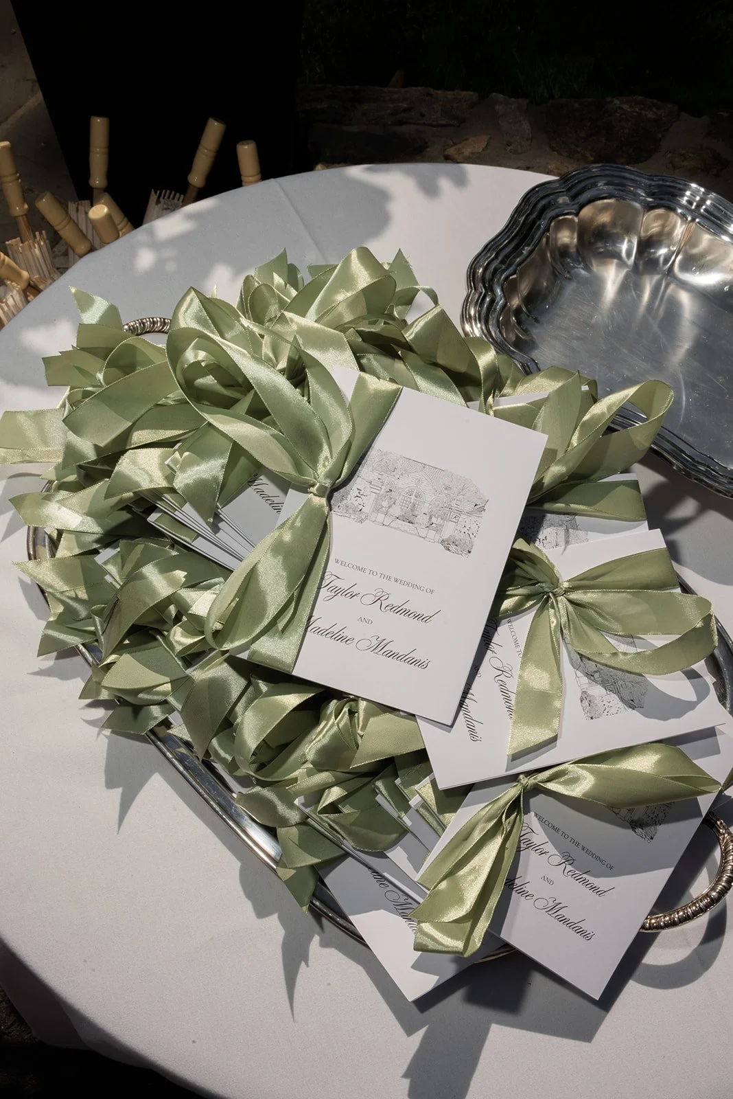 Wedding paper details styled with green olive branches on a round table at Goodstone Inn.