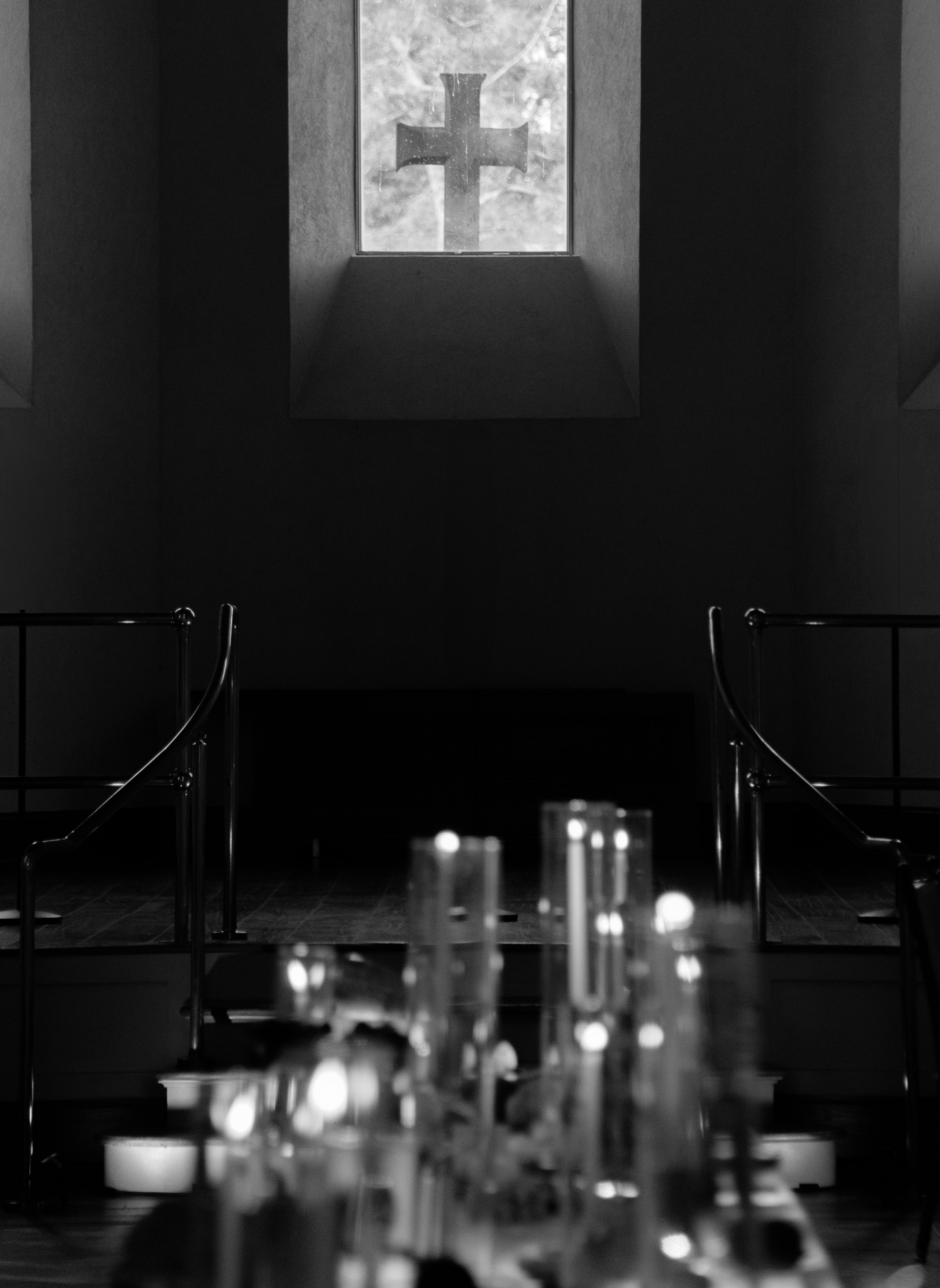Black-and-white candlelit detail of the long rehearsal dinner table at The Abbey Inn & Spa.