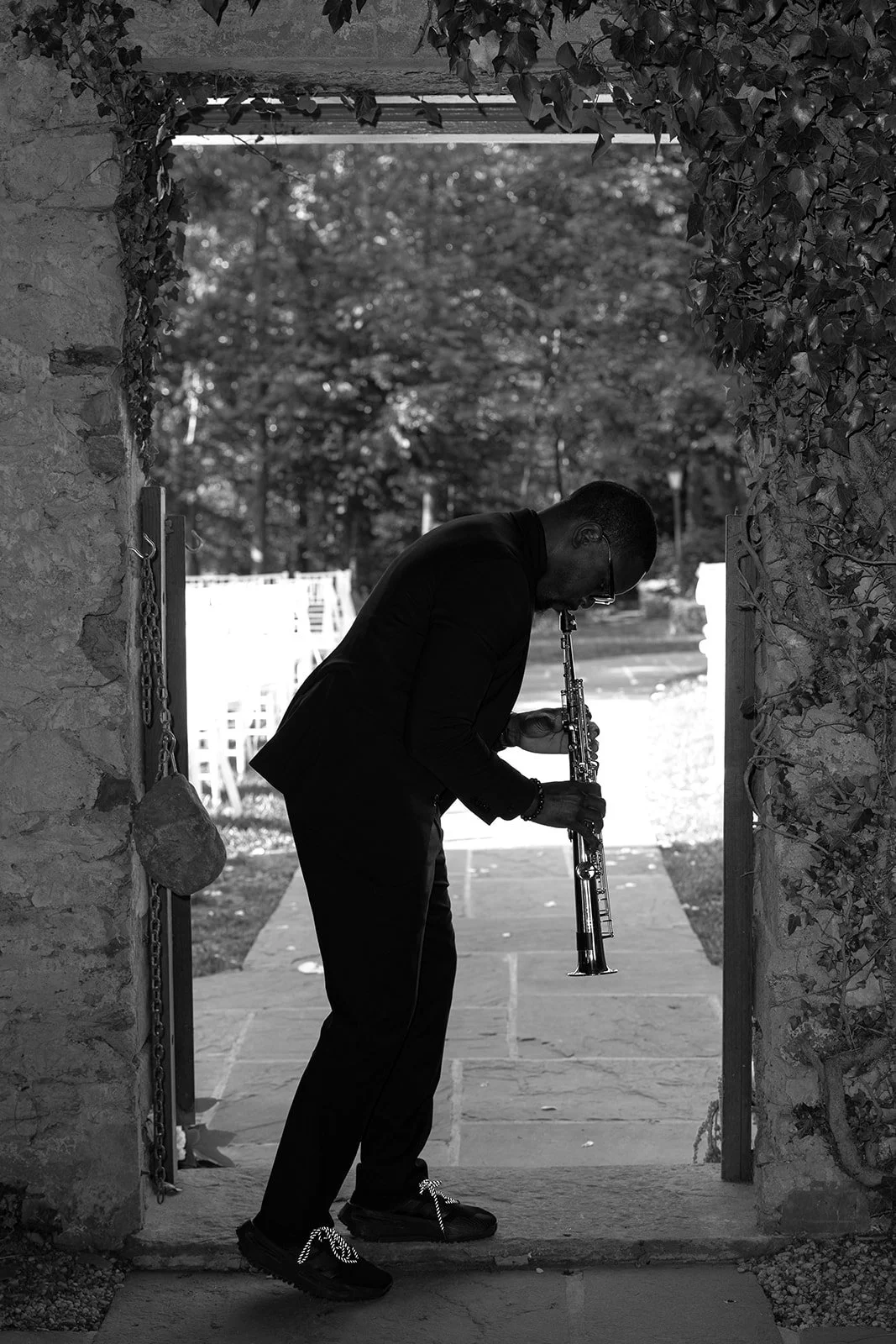 Black-and-white photograph of a musician performing outdoors during a Goodstone Inn wedding cocktail hour.