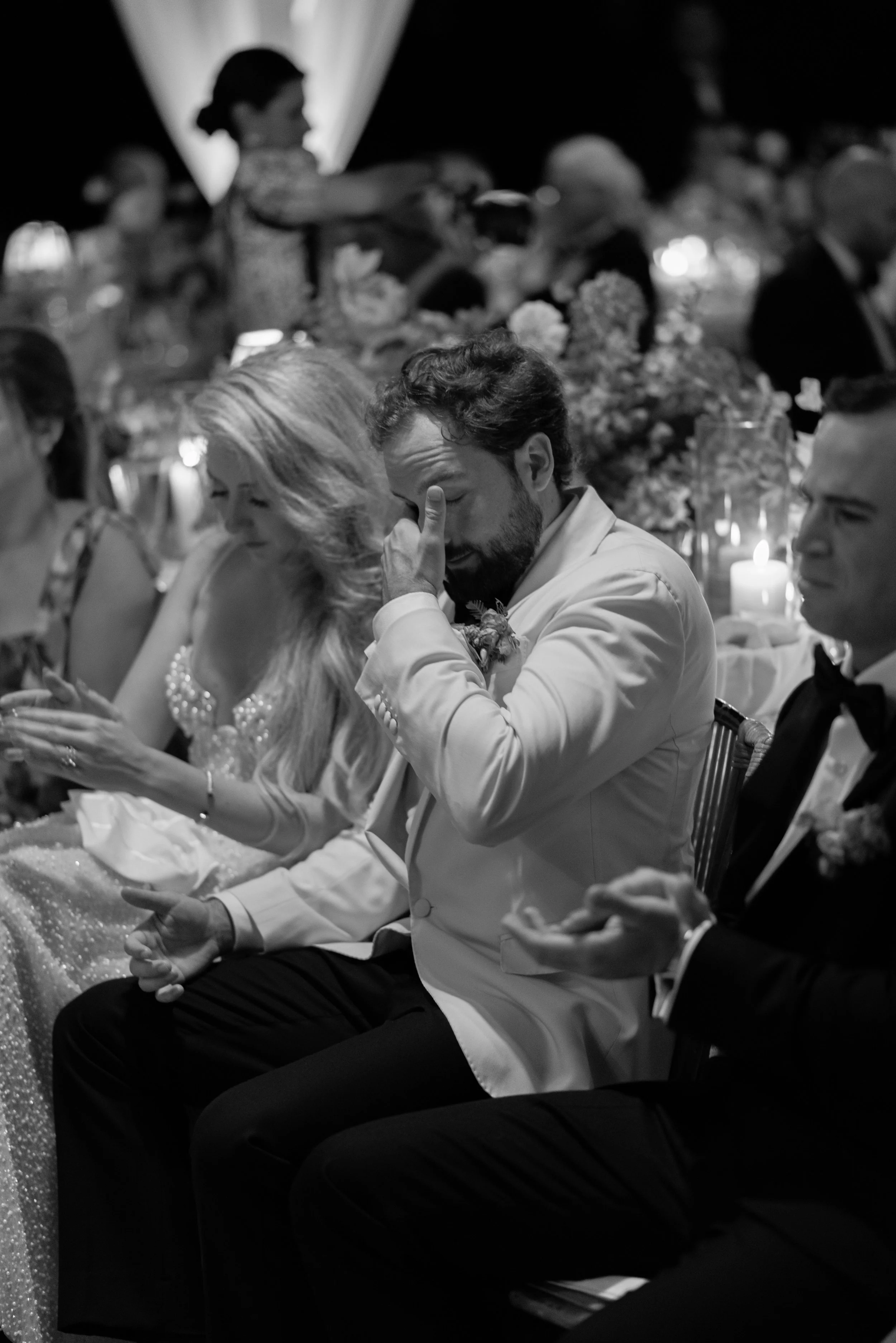 Black-and-white photograph of Trevor becoming emotional during his best man's speech at the wedding reception dinner.