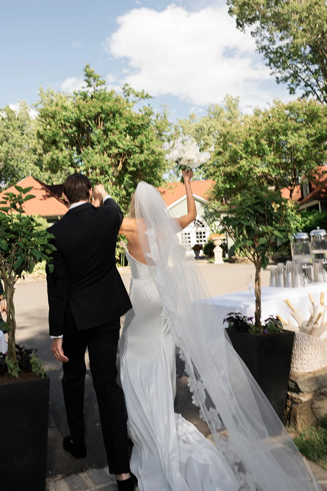Bride and groom walking together through the garden at Goodstone Inn after their ceremony.