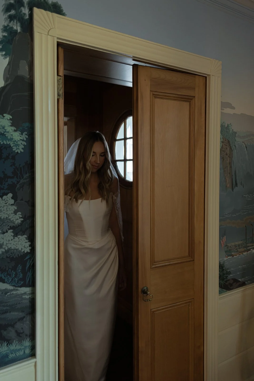 Bride standing framed in a doorway inside the Manor House at Goodstone Inn.