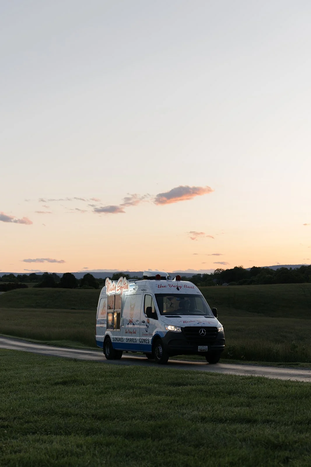 Mr. Softee DMV mobile soft serve ice cream truck drives up at sunset to join the wedding reception for a sweet treat. 
