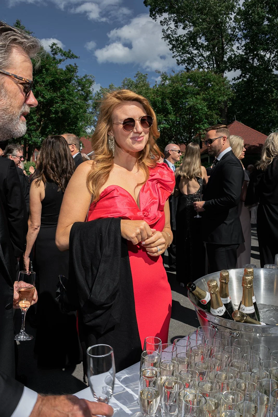 Wedding guests in colorful formalwear holding cocktails outdoors at Goodstone Inn.