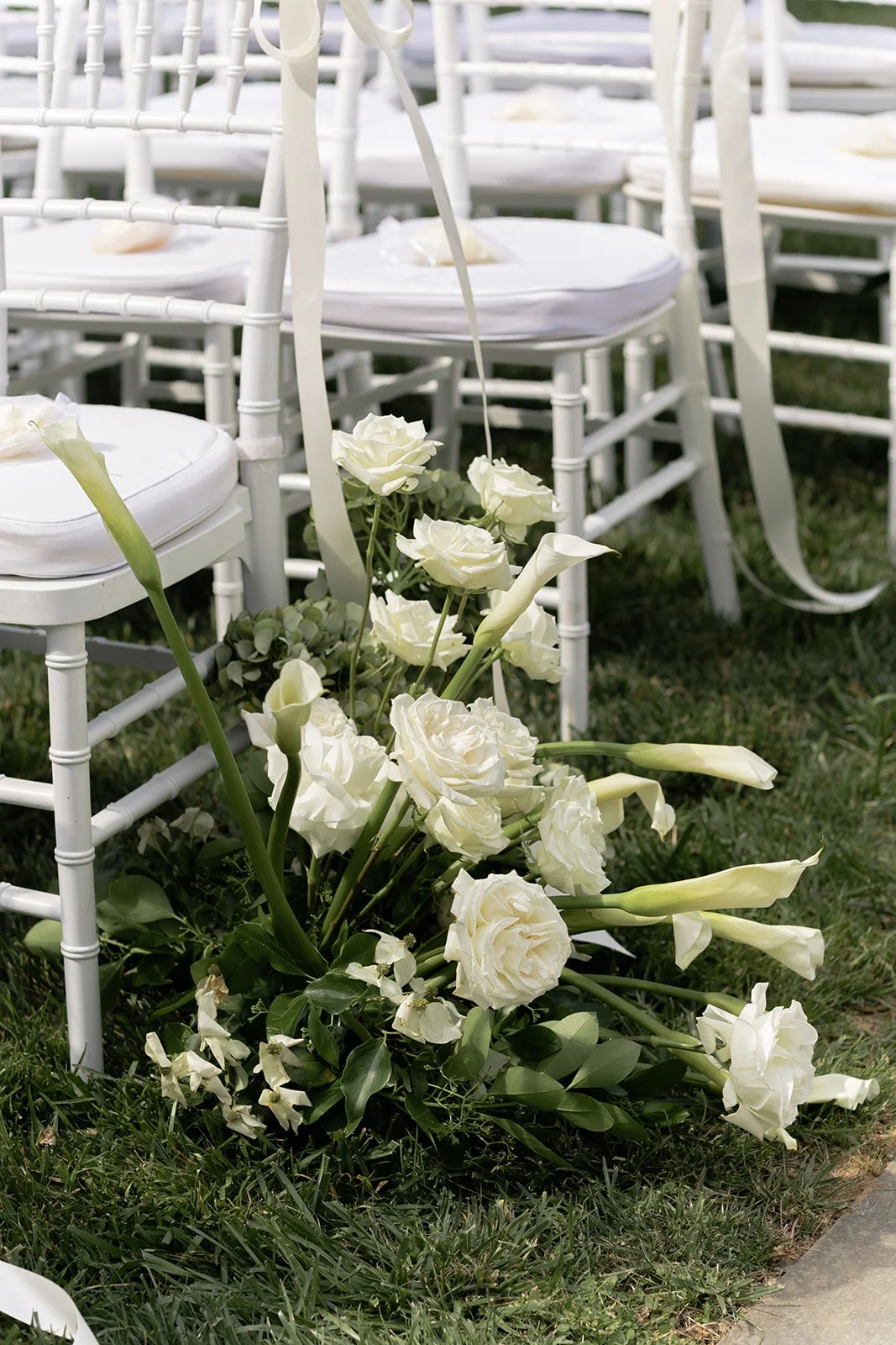 White ceremony chairs and garden flowers arranged outdoors for a wedding at Goodstone Inn.v