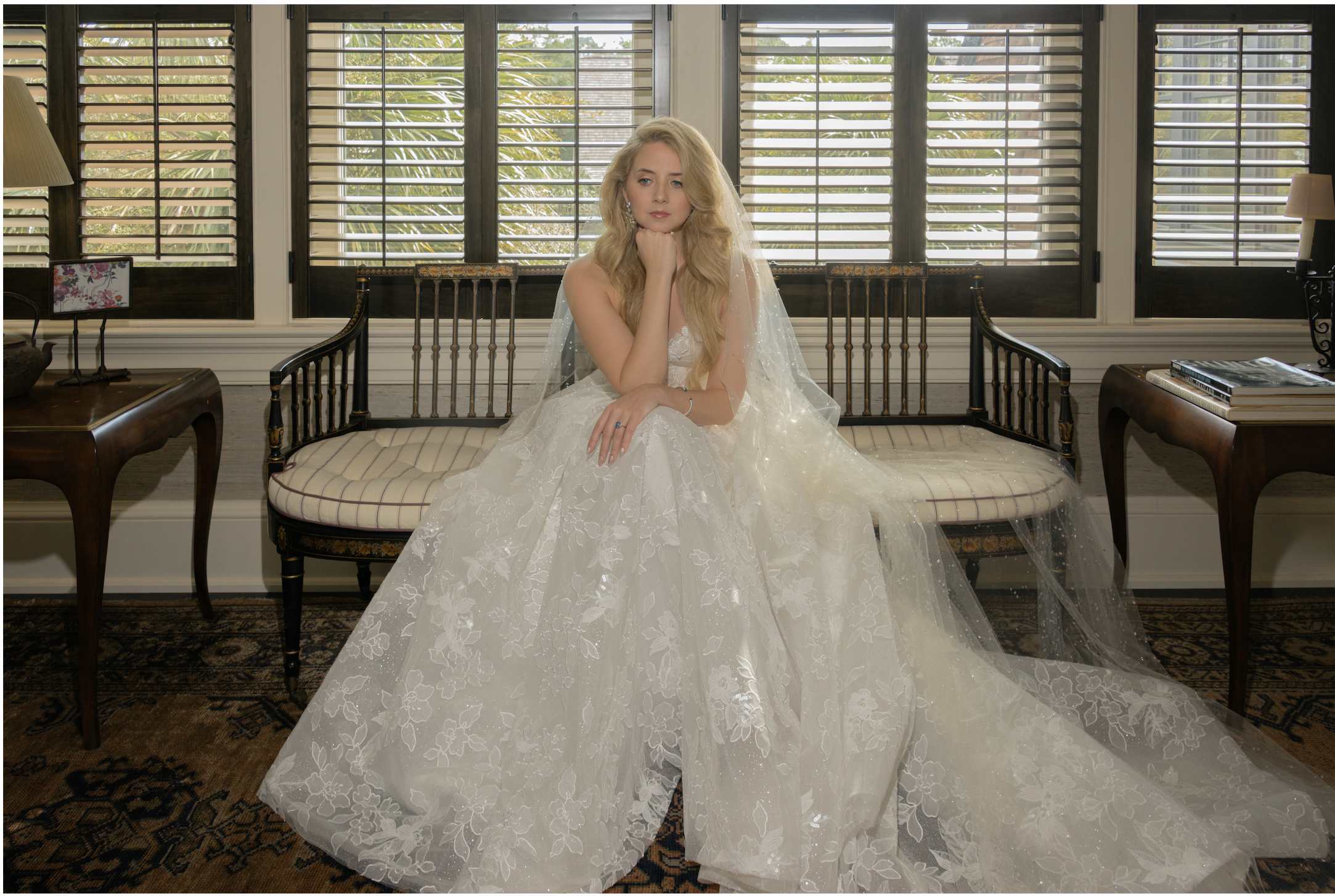 Katie sits beneath shuttered windows in her lace Galia Lahav gown for an editorial bridal portrait before the ceremony.