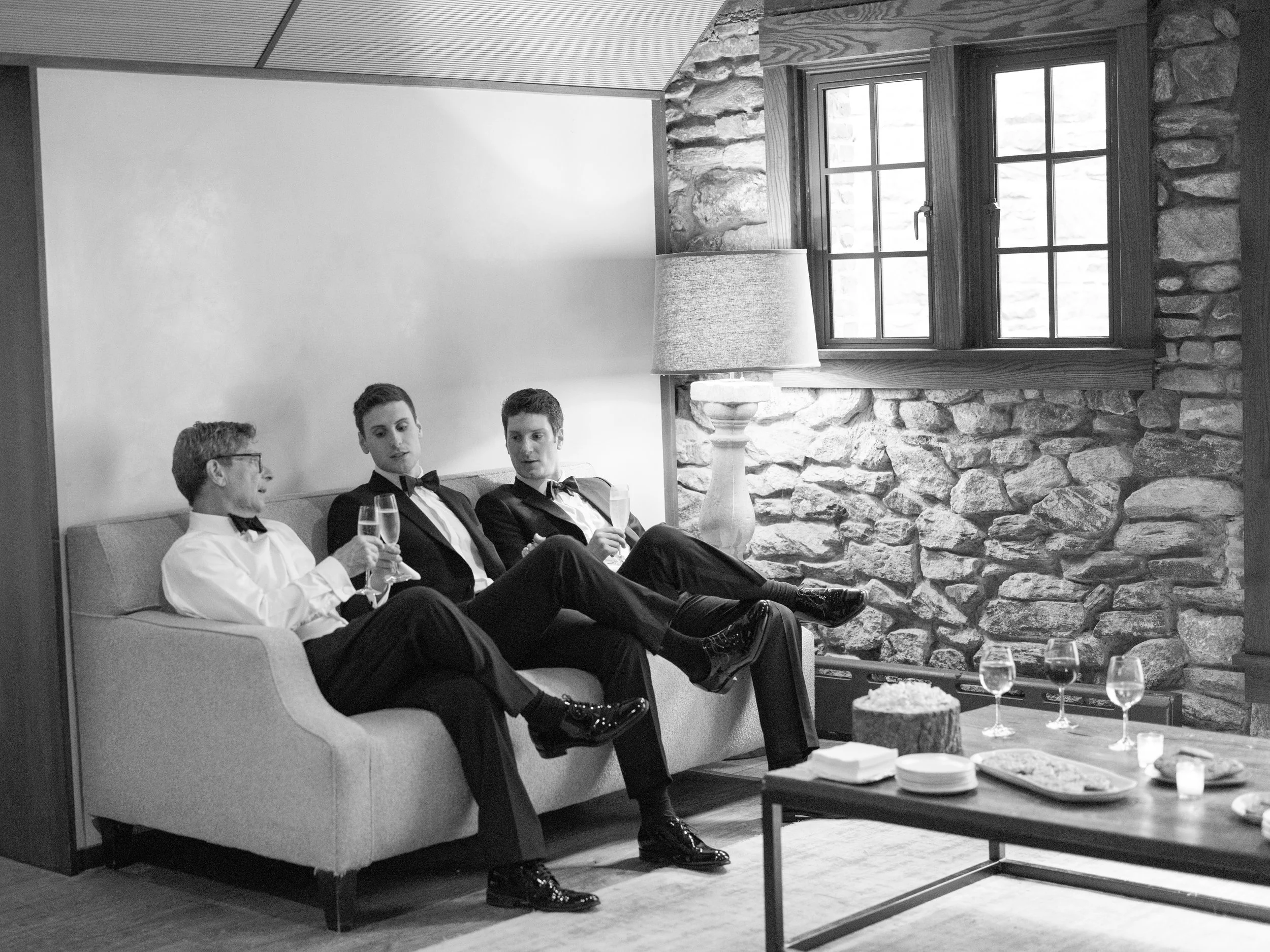 The groom and his father and brother toast with champagne on the morning of the wedding.