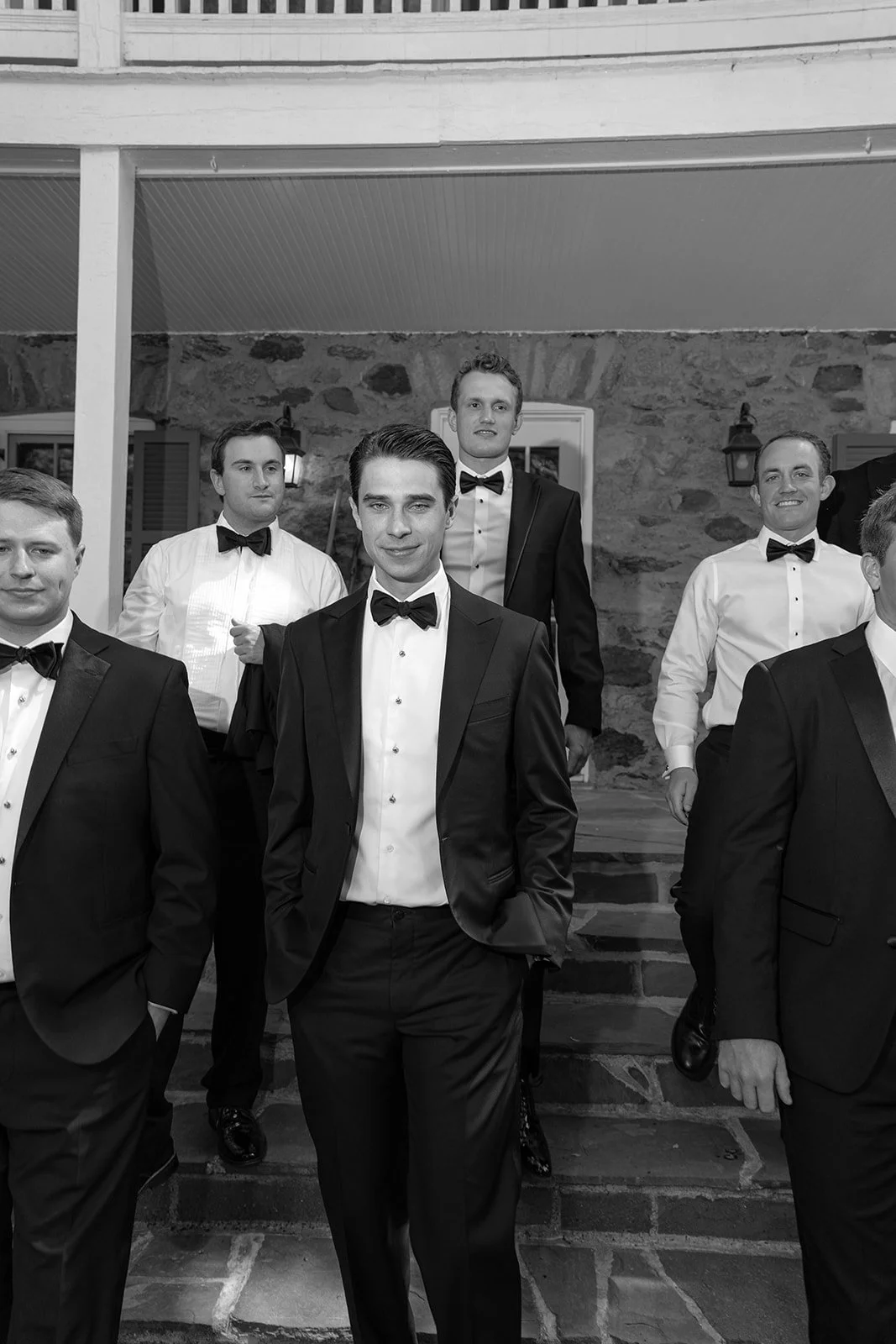 Black-and-white portrait of the groom and groomsmen standing together at Goodstone Inn.