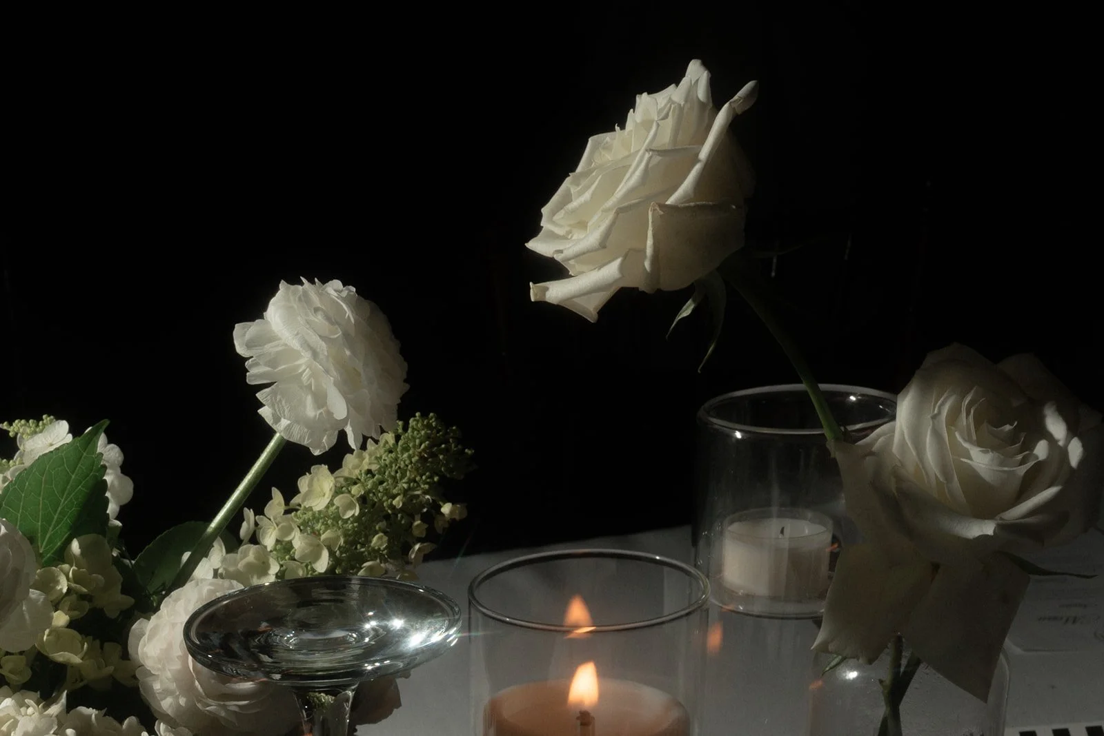 White flowers and candlelight glowing against the dark during the evening reception at Goodstone Inn.