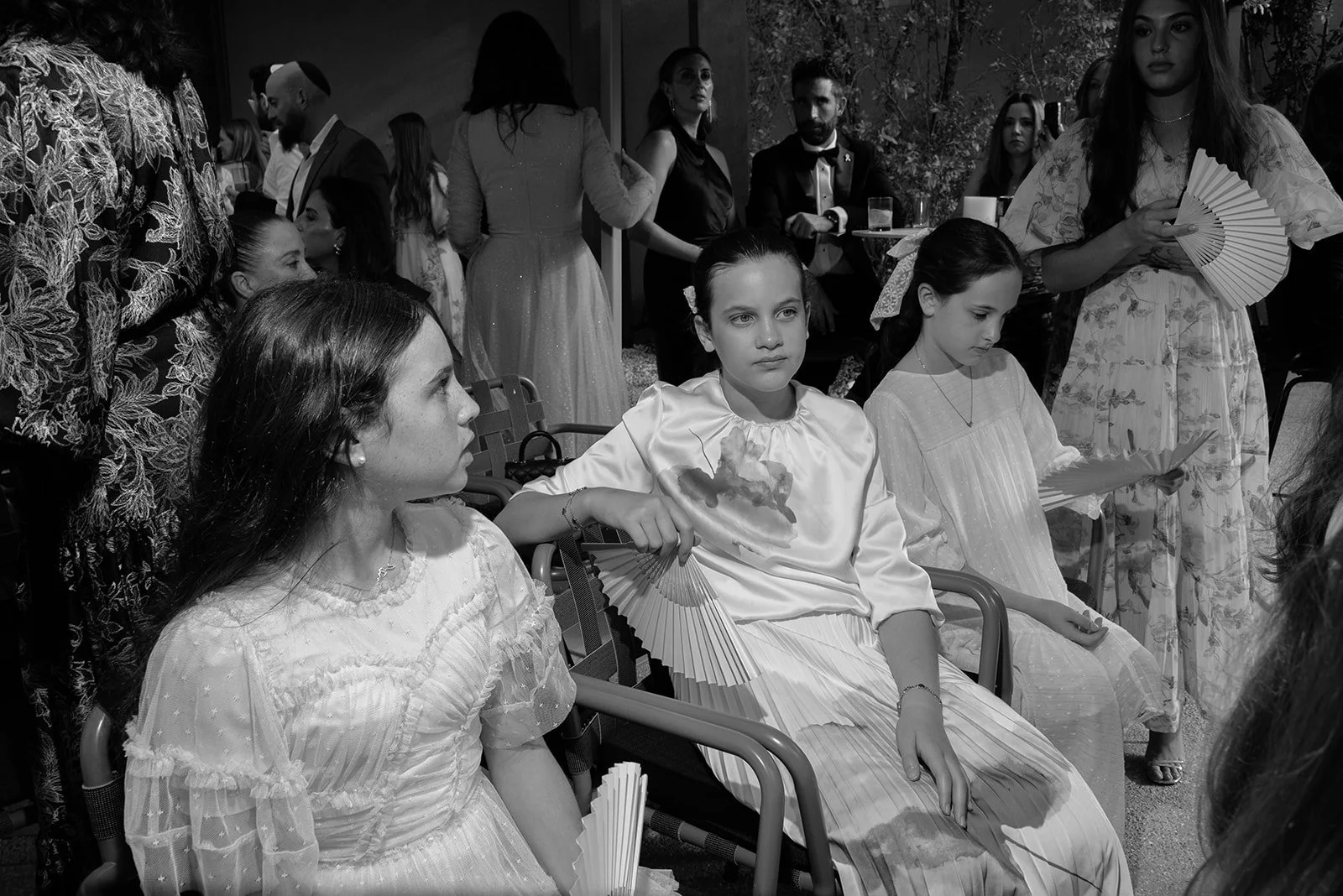 Black and white candid photograph of children participating in a Jewish Orthodox wedding ceremony, capturing a quiet and emotional moment during the West Palm Beach, Florida celebration.