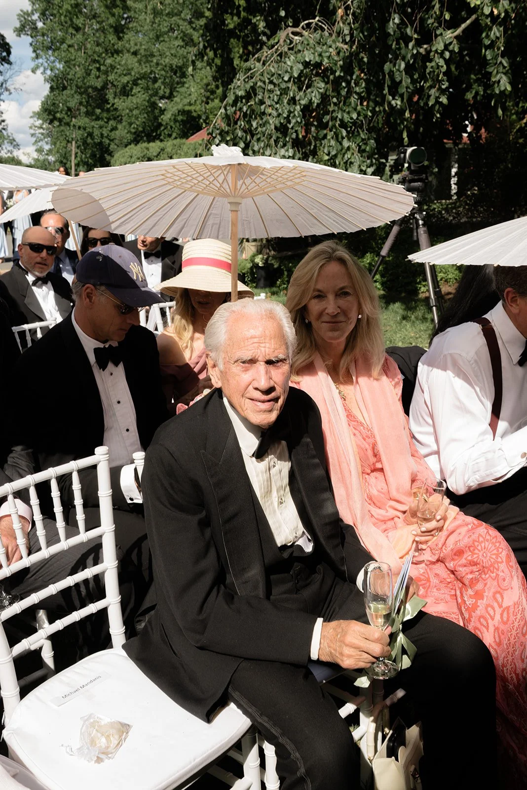 Wedding guests seated beneath ivory parasols during the outdoor Ivy Wall ceremony at Goodstone Inn.